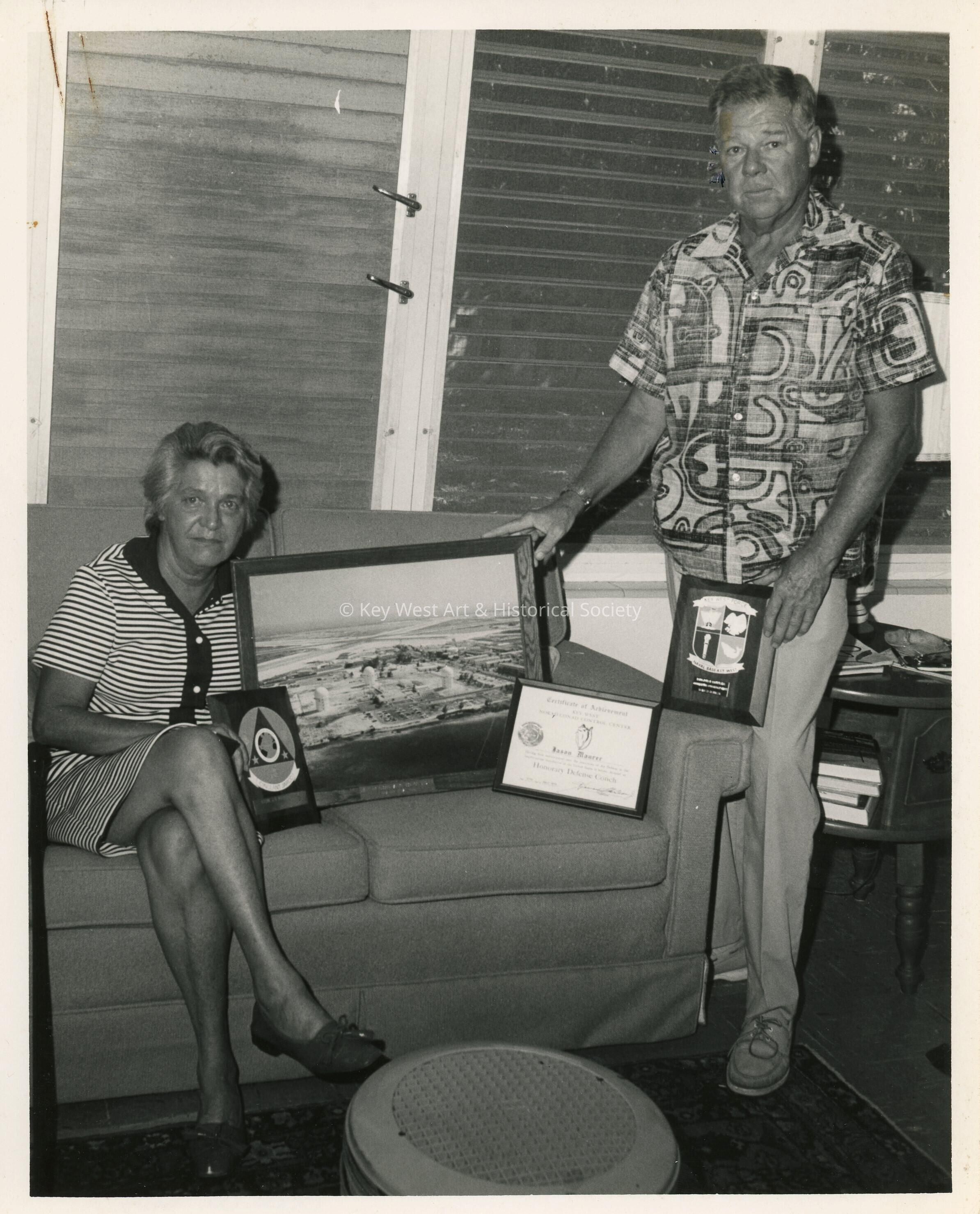An unknown man and woman holding plaques