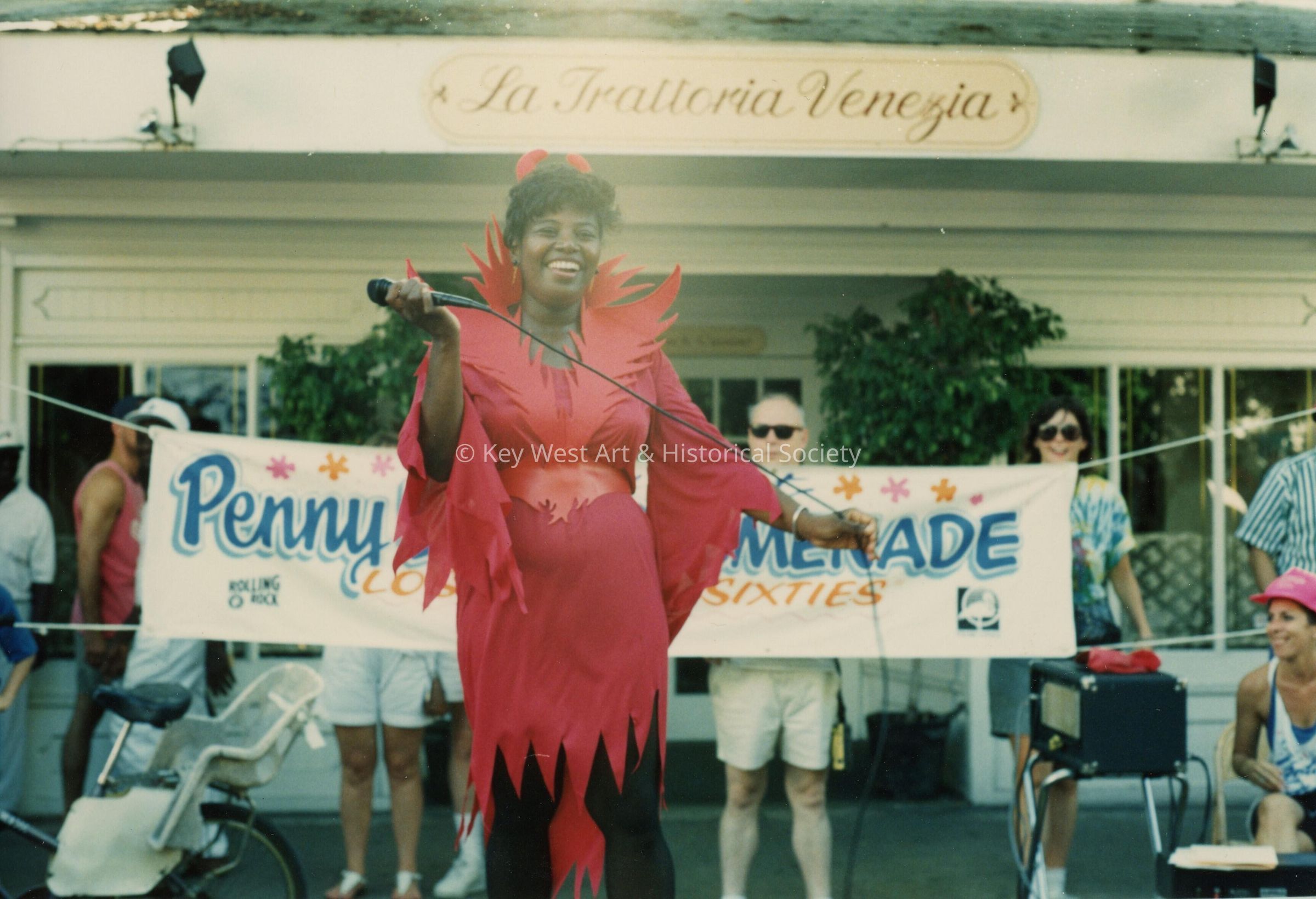 An unknown woman on a stage in front of the La Trattoria Venezia.