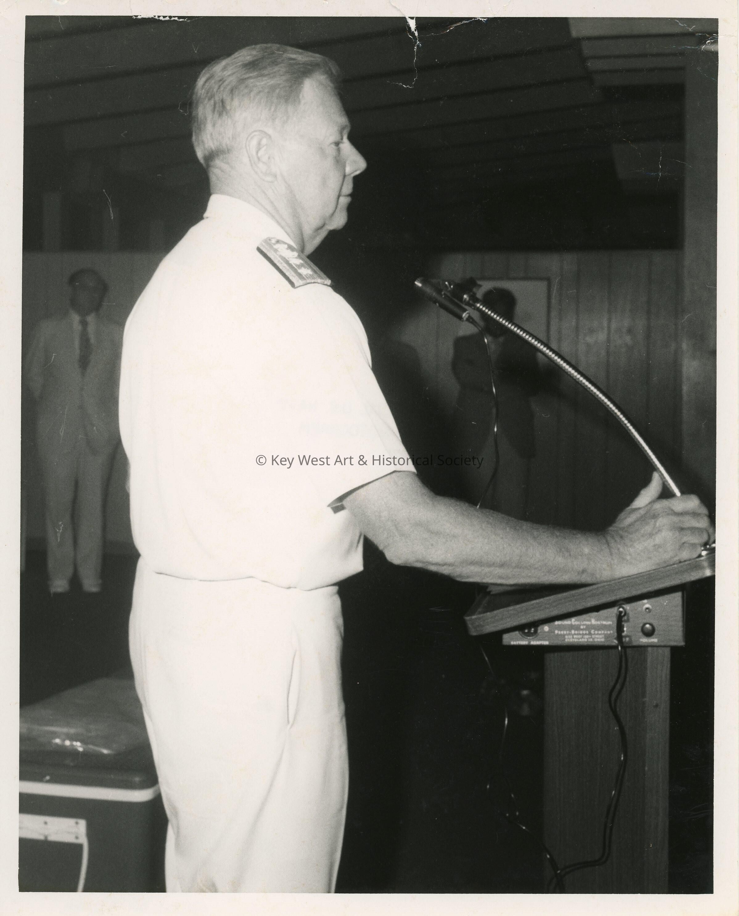 An unknown man in uniform standing at a podium