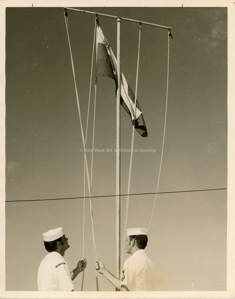 2 Men in uniform with a flag