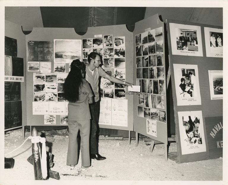 2 Unknown people looking at photographs