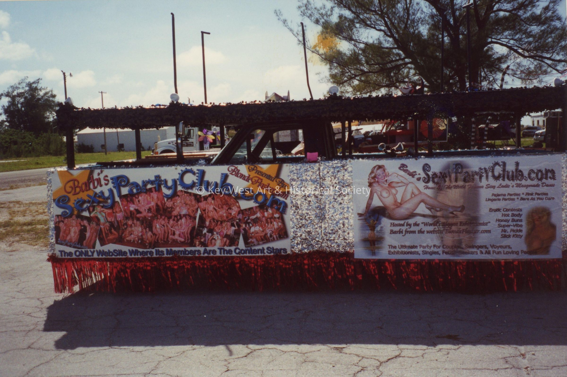 A float in the parade that reads Barbi's sexy party club.com.