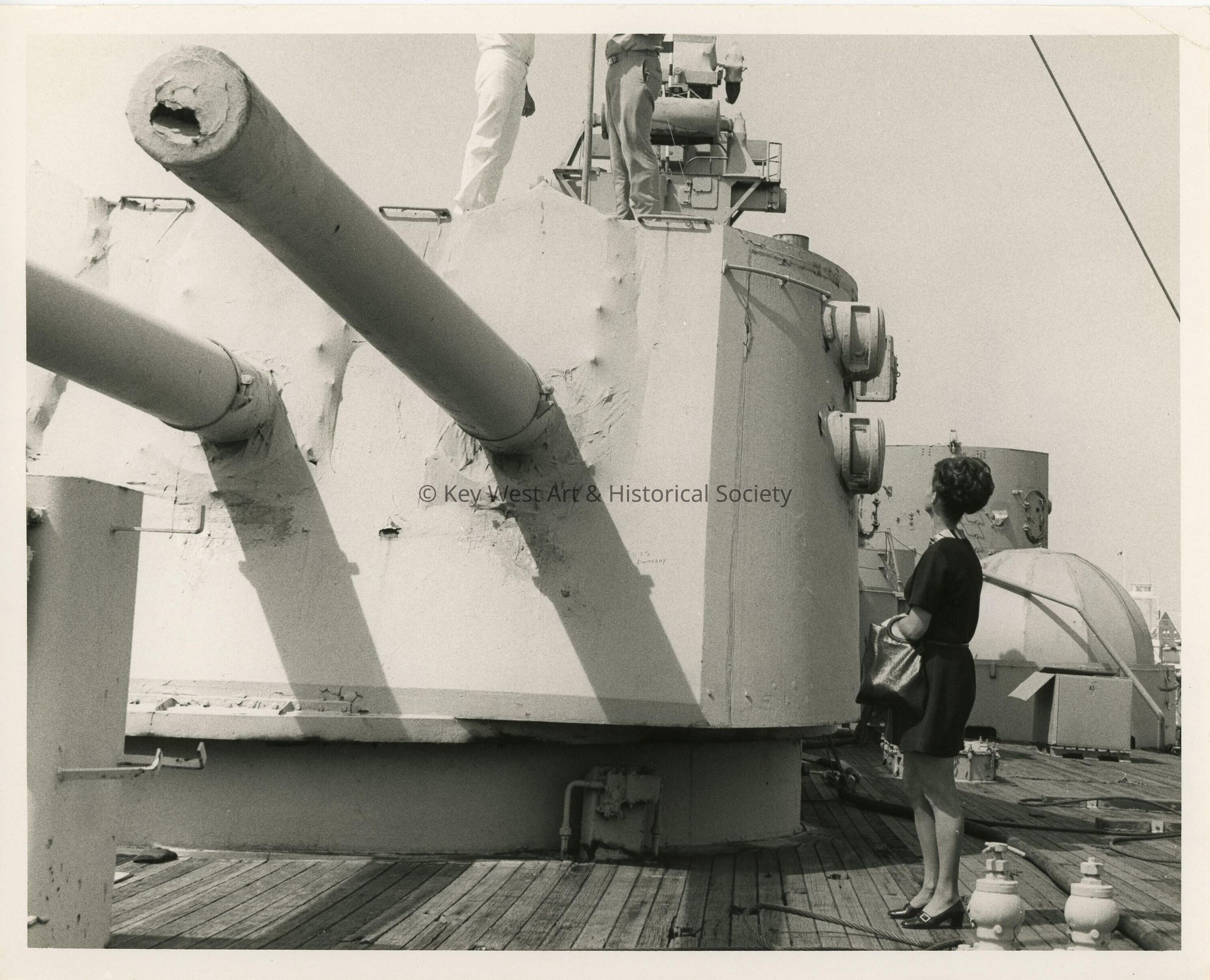 An unknown woman looking at a few men on a machine