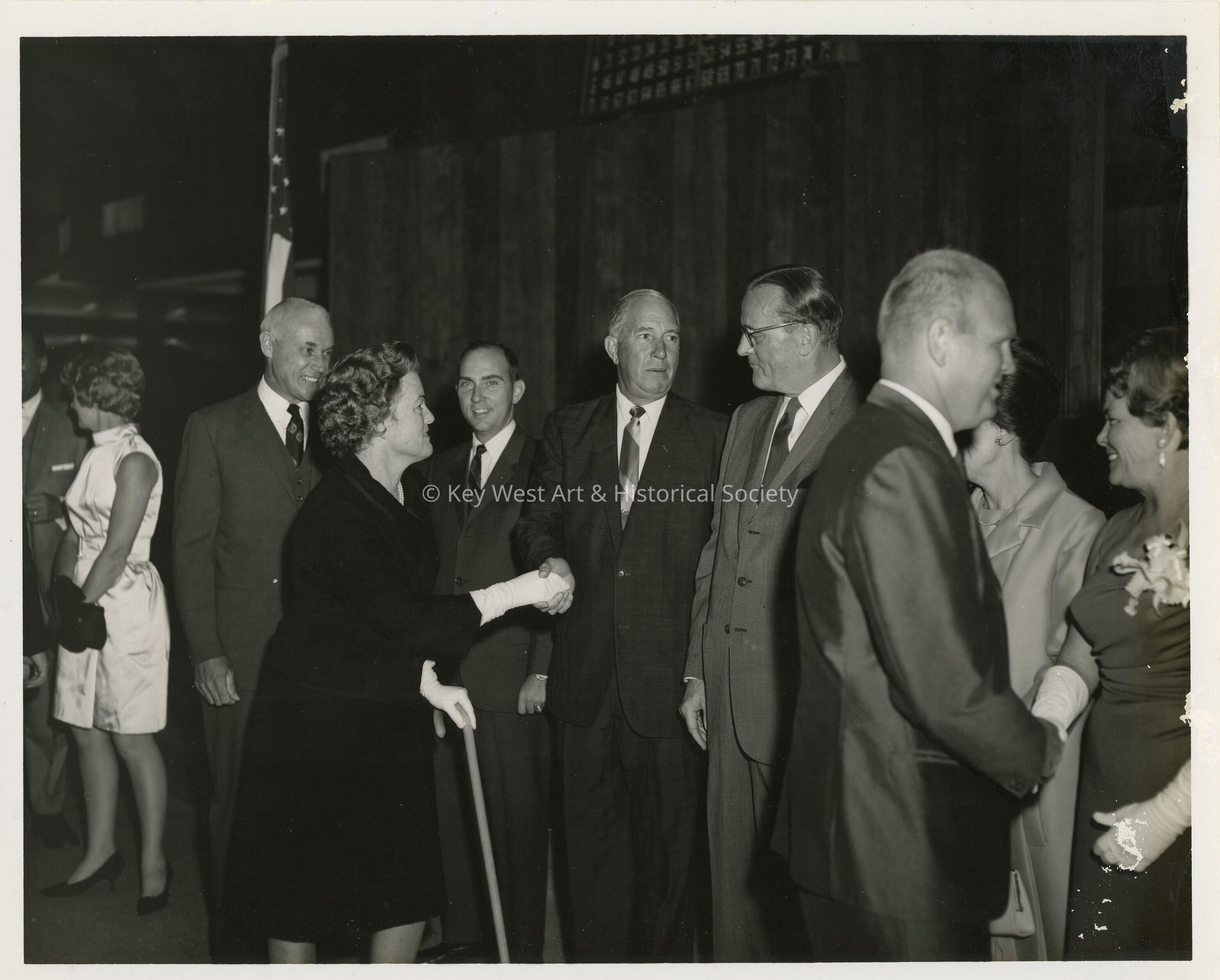 A group of unknown people at a party greeting each other