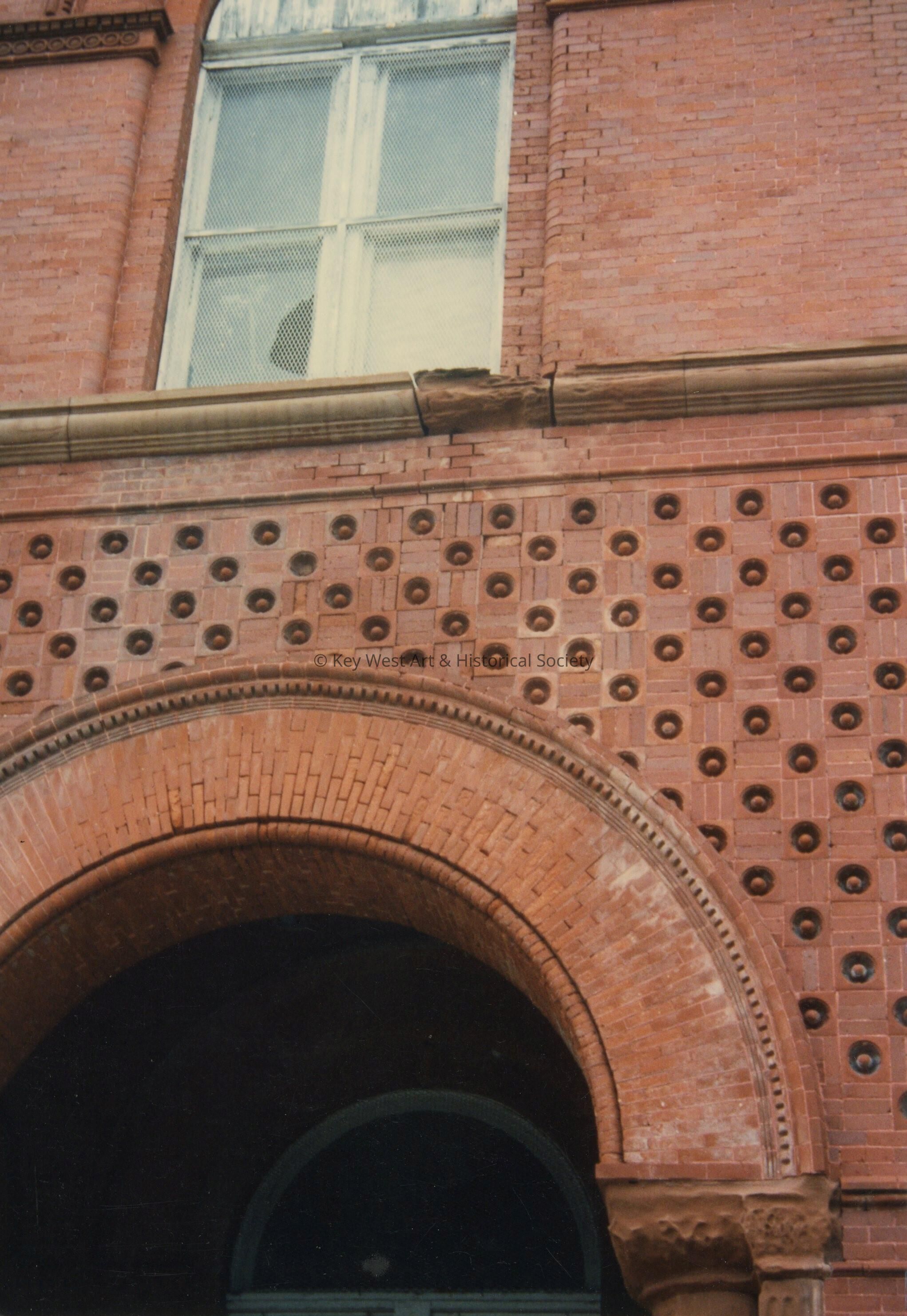 A brick arch and second floor window.