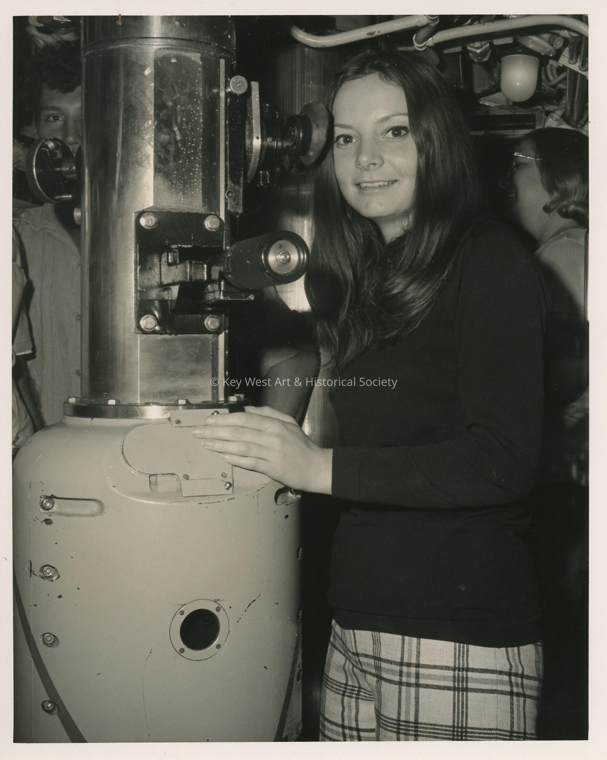 An unknown woman standing next to a machine
