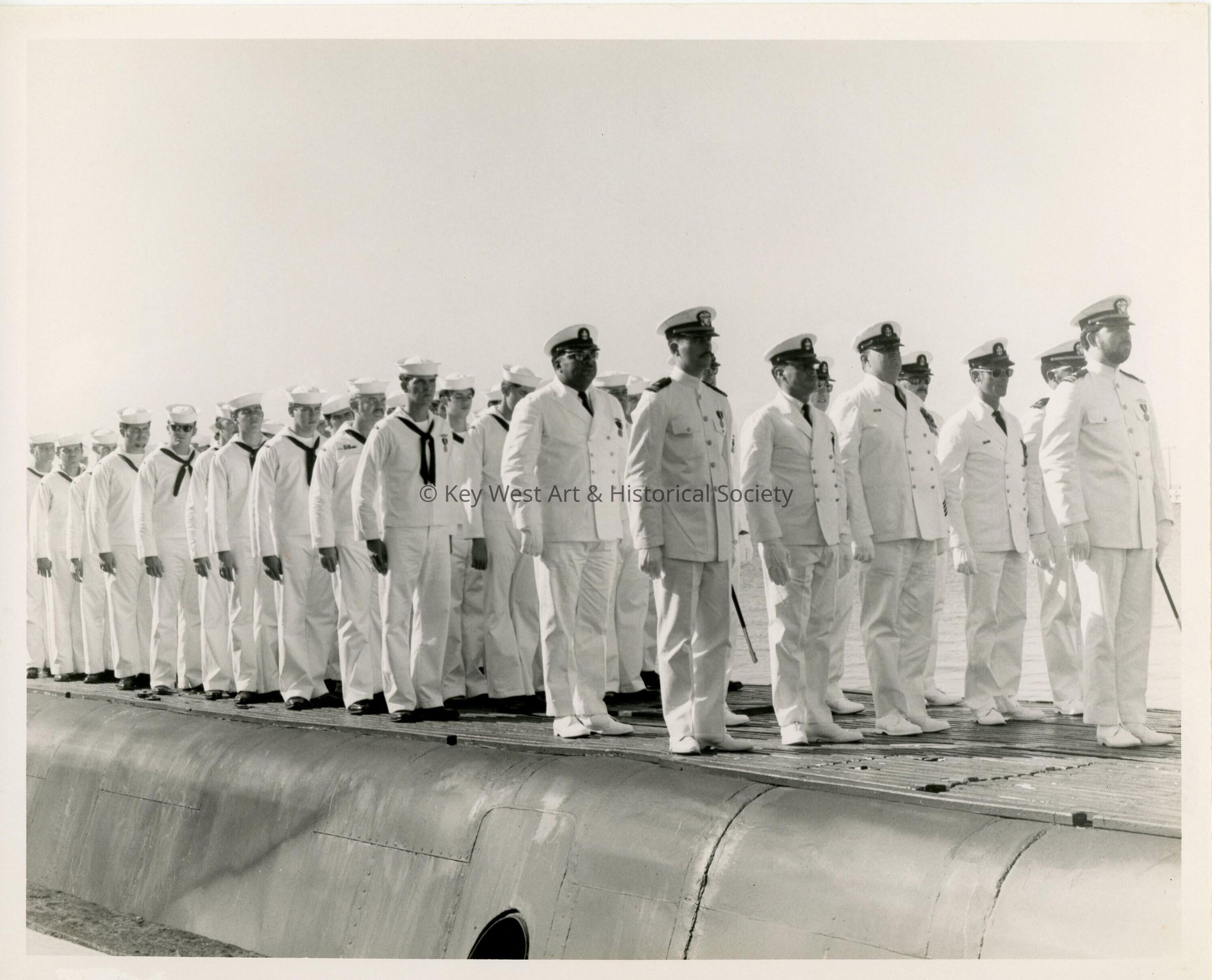 A group of men in  uniform standing on a ship