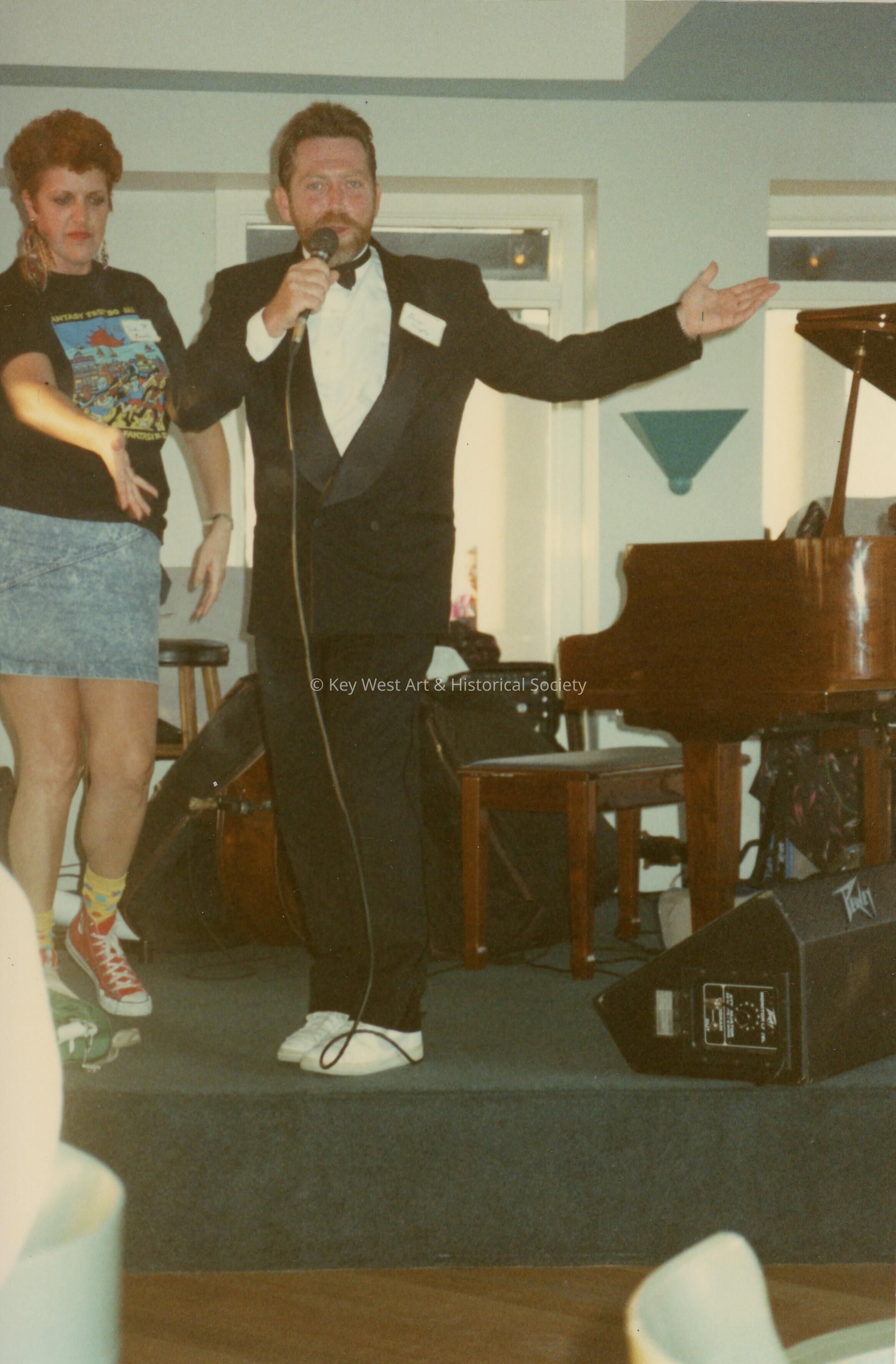 An unknown man speaking on a stage.