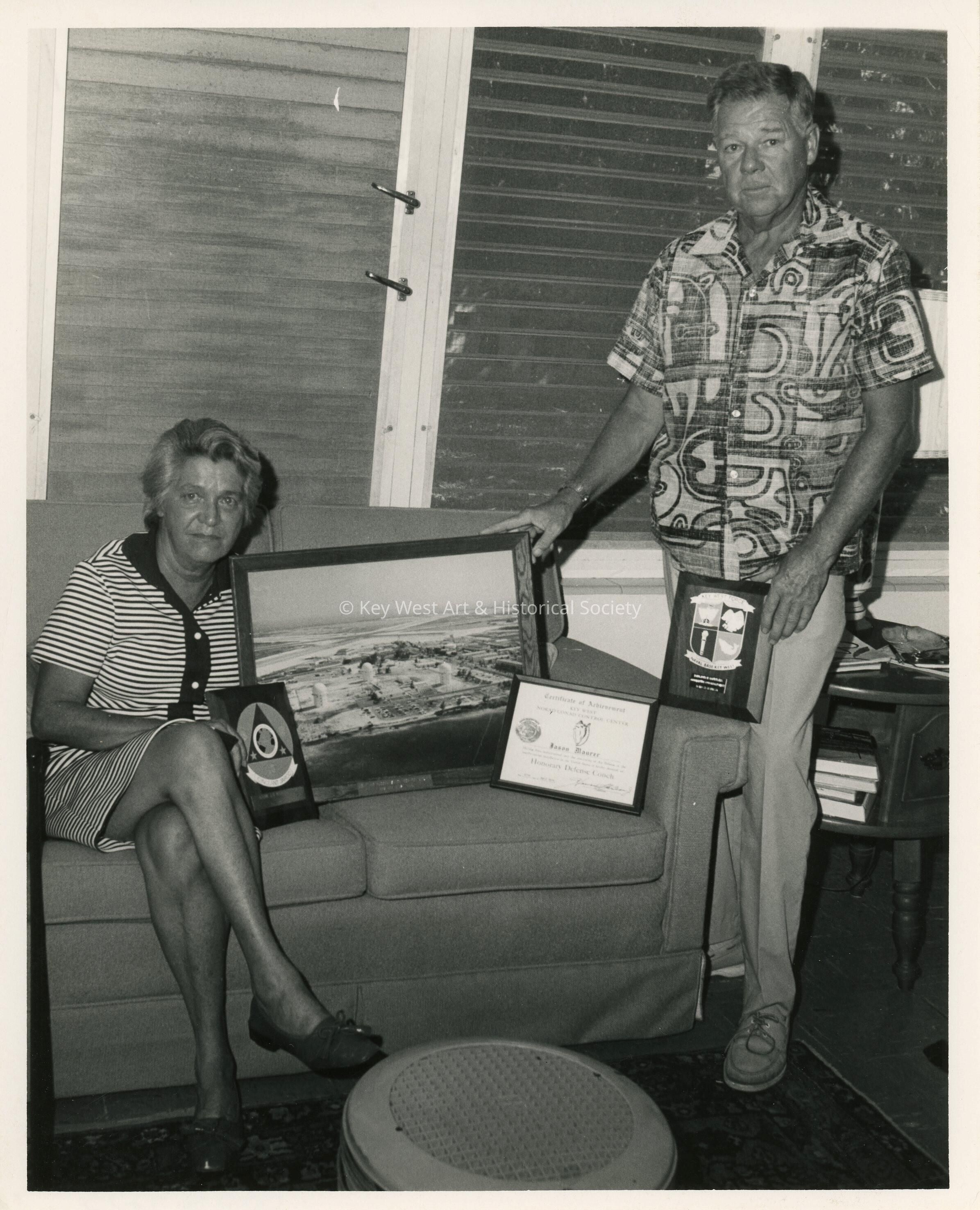 An unknown woman and man showing off a few awards