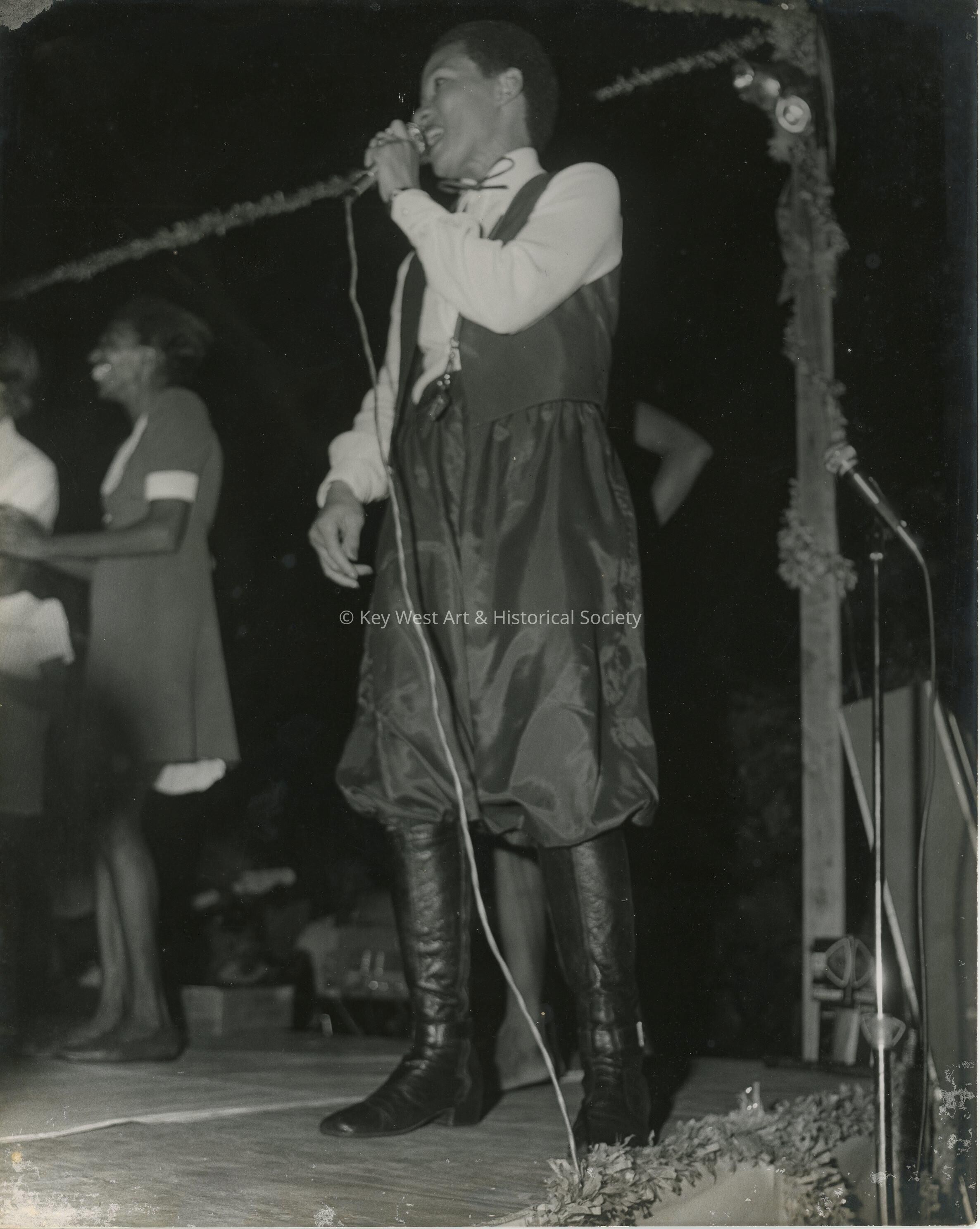 An Unknown woman singing into a microphone