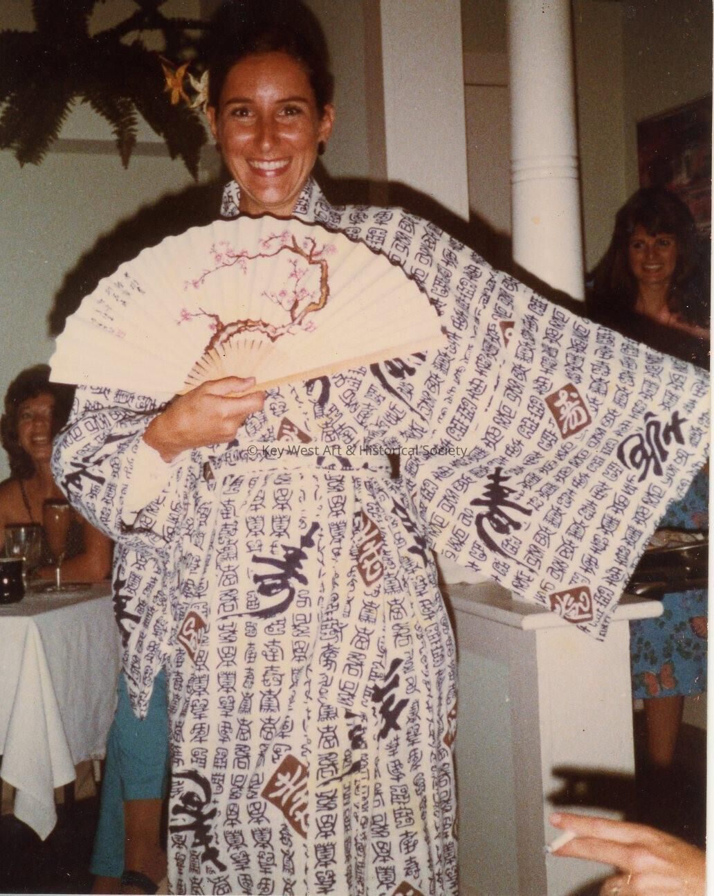 An unknown woman holding a fan