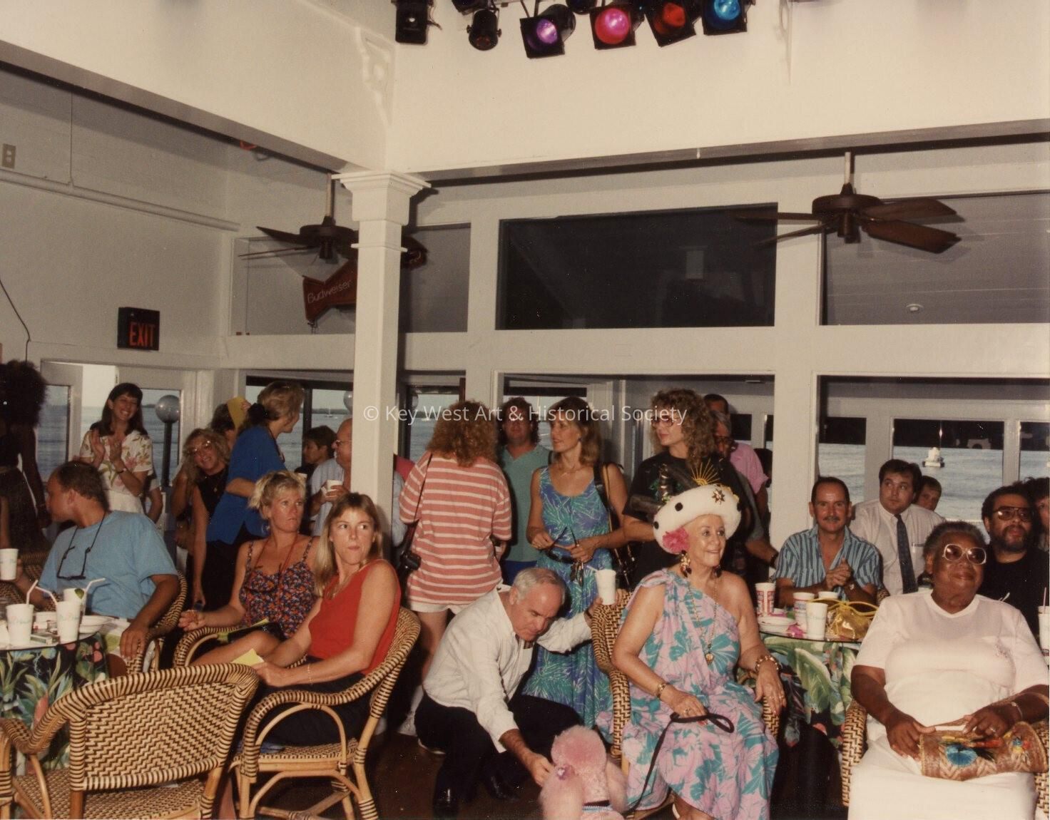 A group of unknown people standing and sitting.
