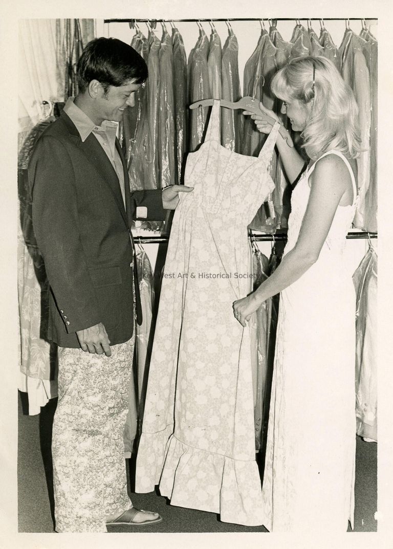 2 Unknown people looking at a dress