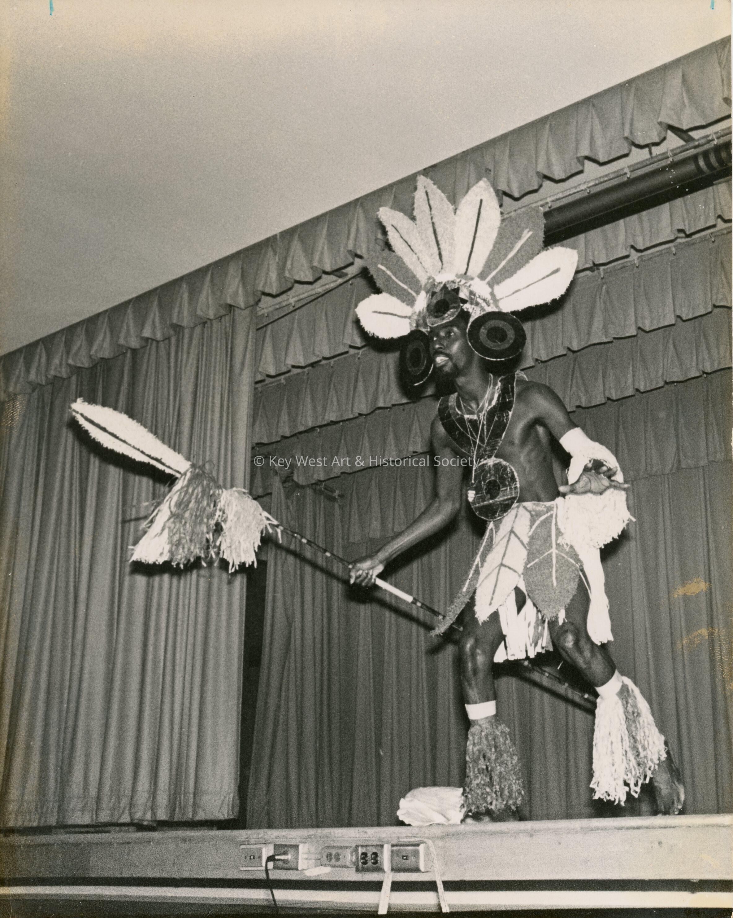 An unknown man in costume dancing on a stage