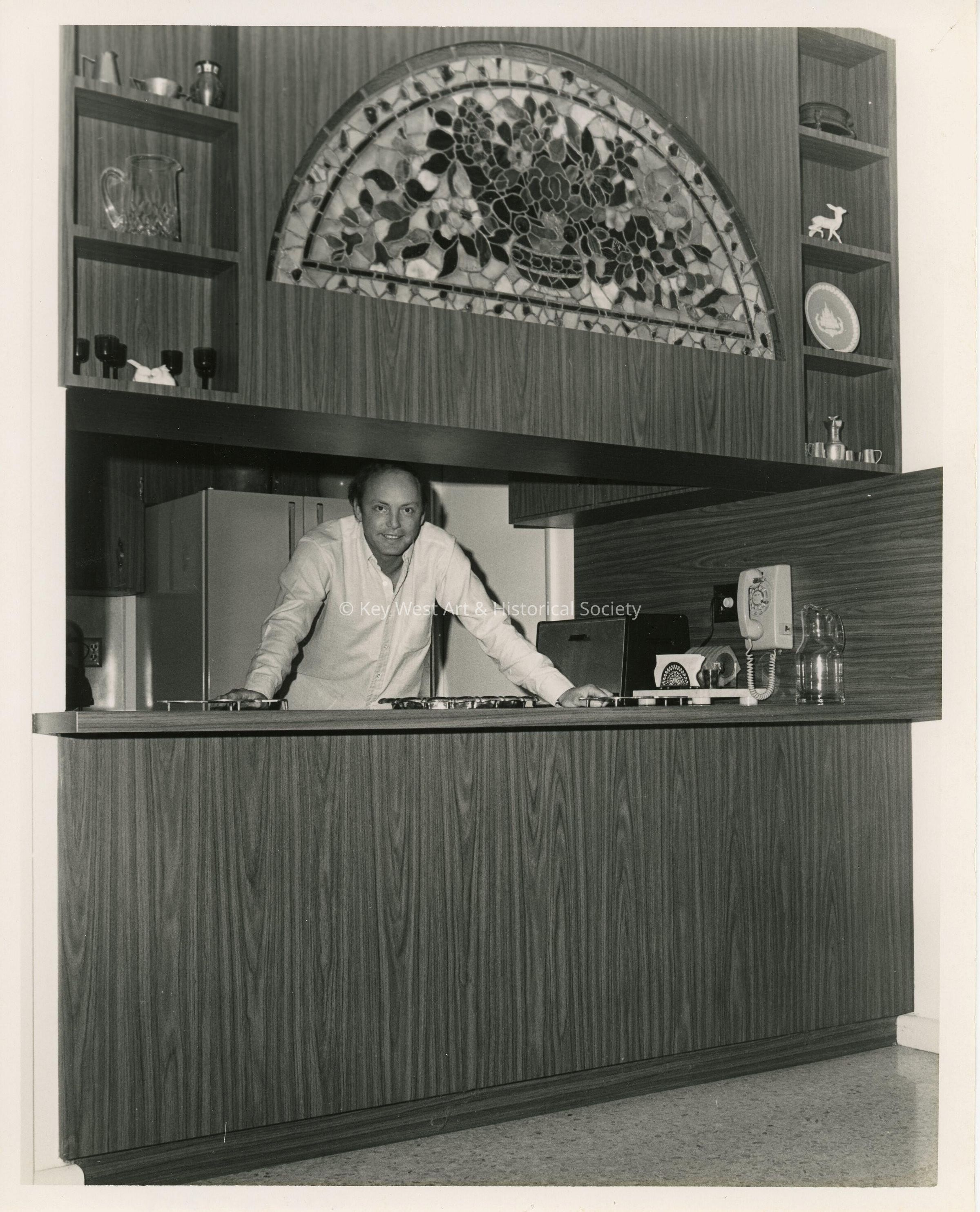 An unknown man standing in a kitchen