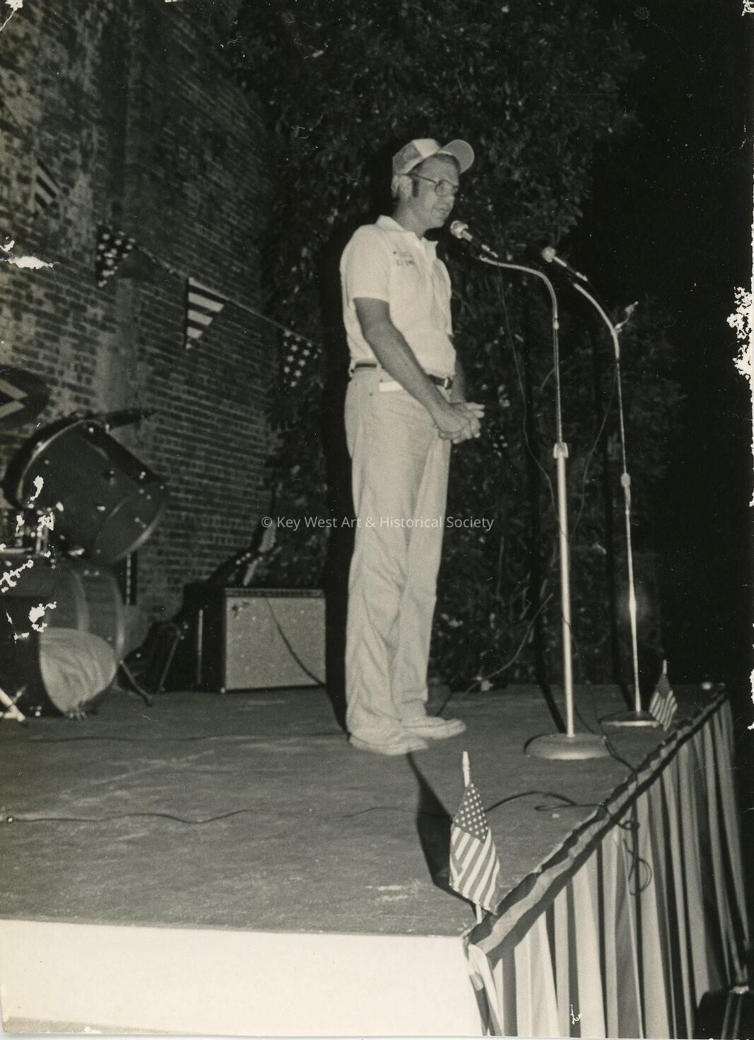 An unknown man standing at a microphone