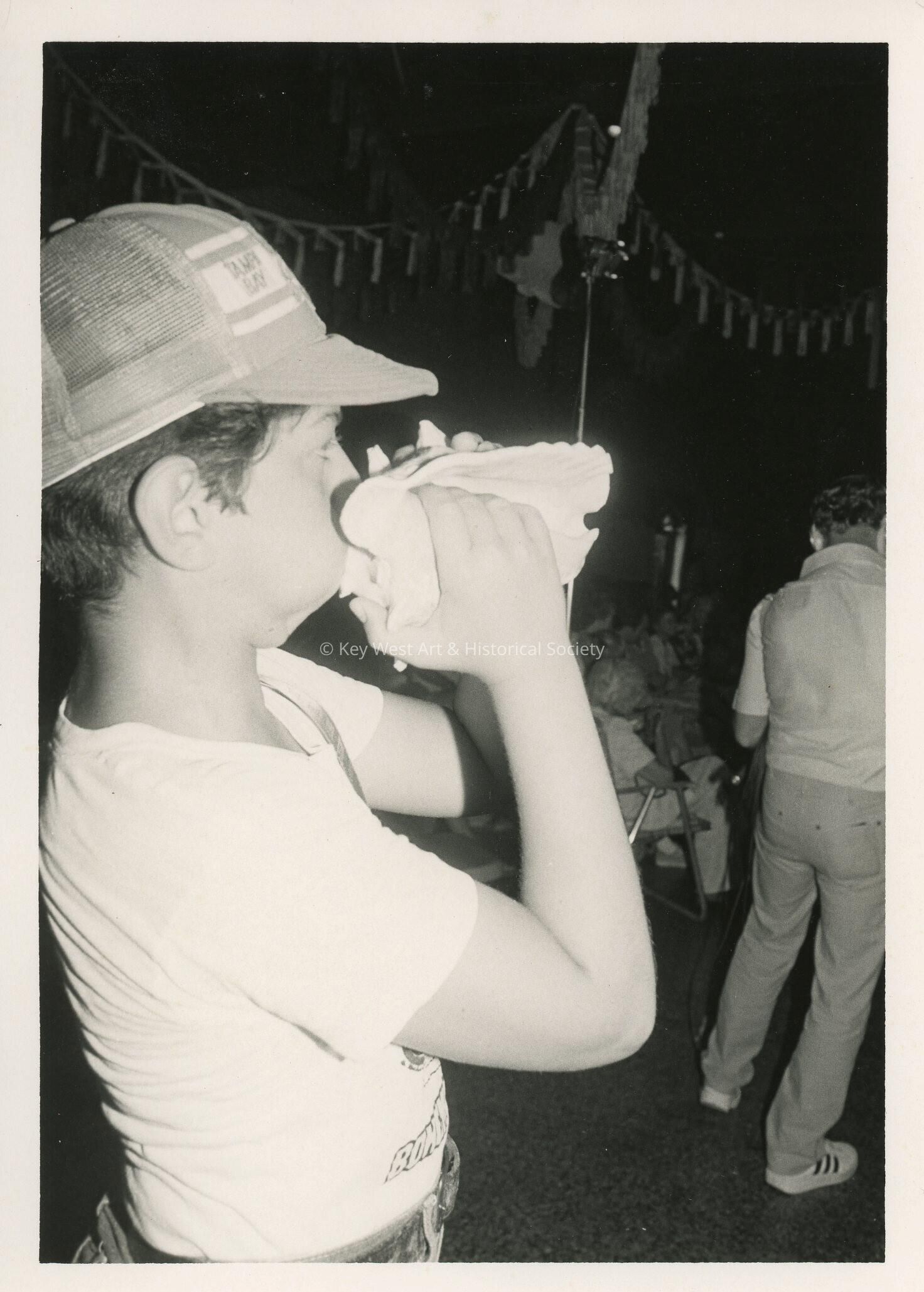 An unknown child blowing in a conch