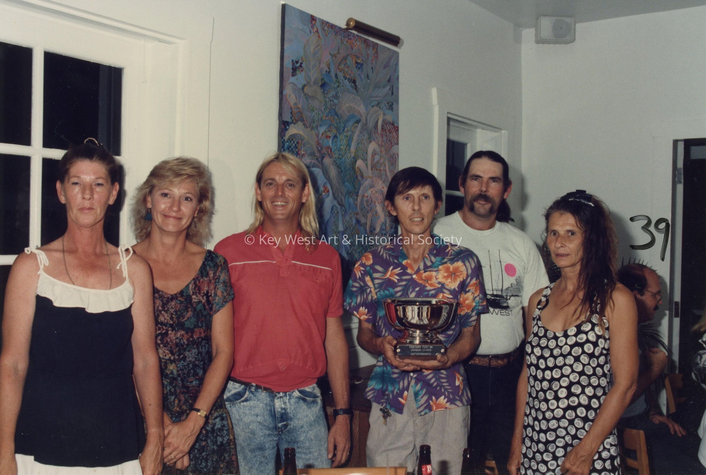 A group of unknown people accepting a trophy.