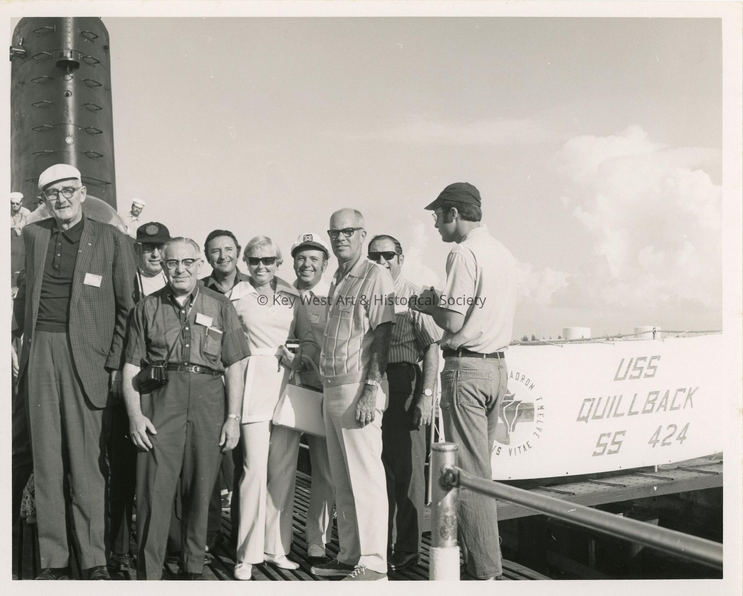 A group of unknown people standing next to the USS Quillback