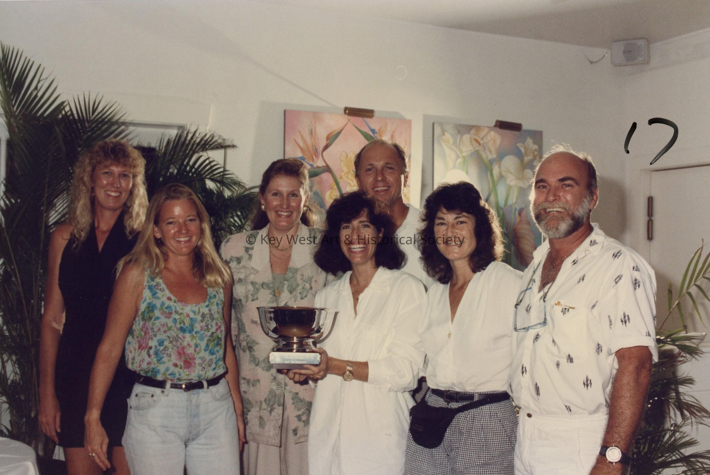 A group of unknown people accepting a trophy.
