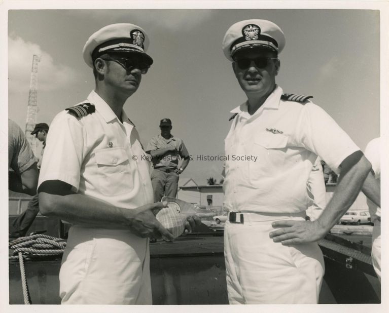 2 Unknown men in uniform, one is holding a shell