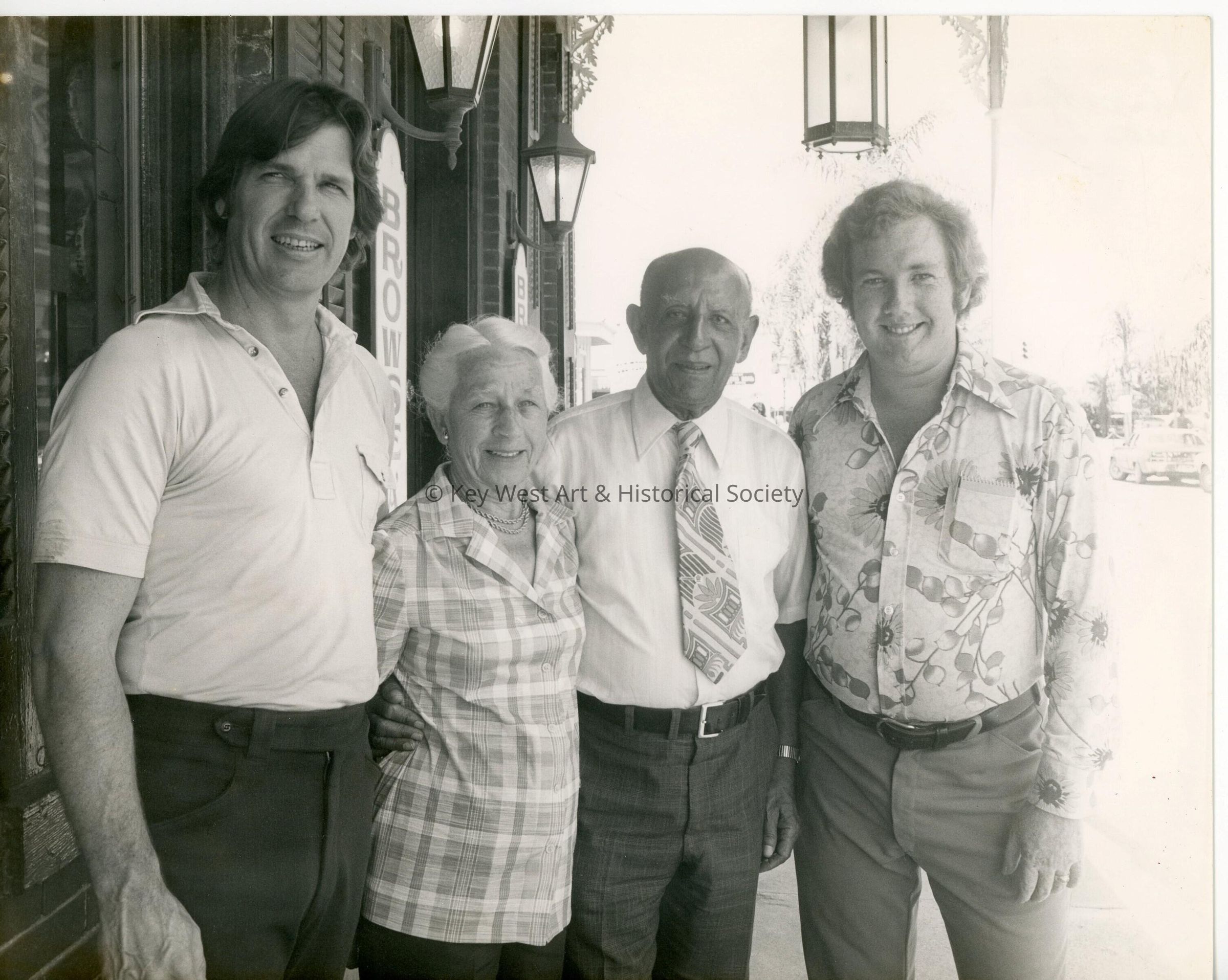 4 Unknown people standing in front of a building