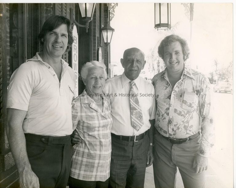 4 Unknown people standing in front of a building