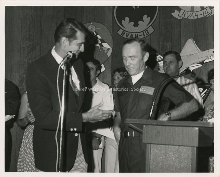 2 Unknown men talking into microphones at a ceremony