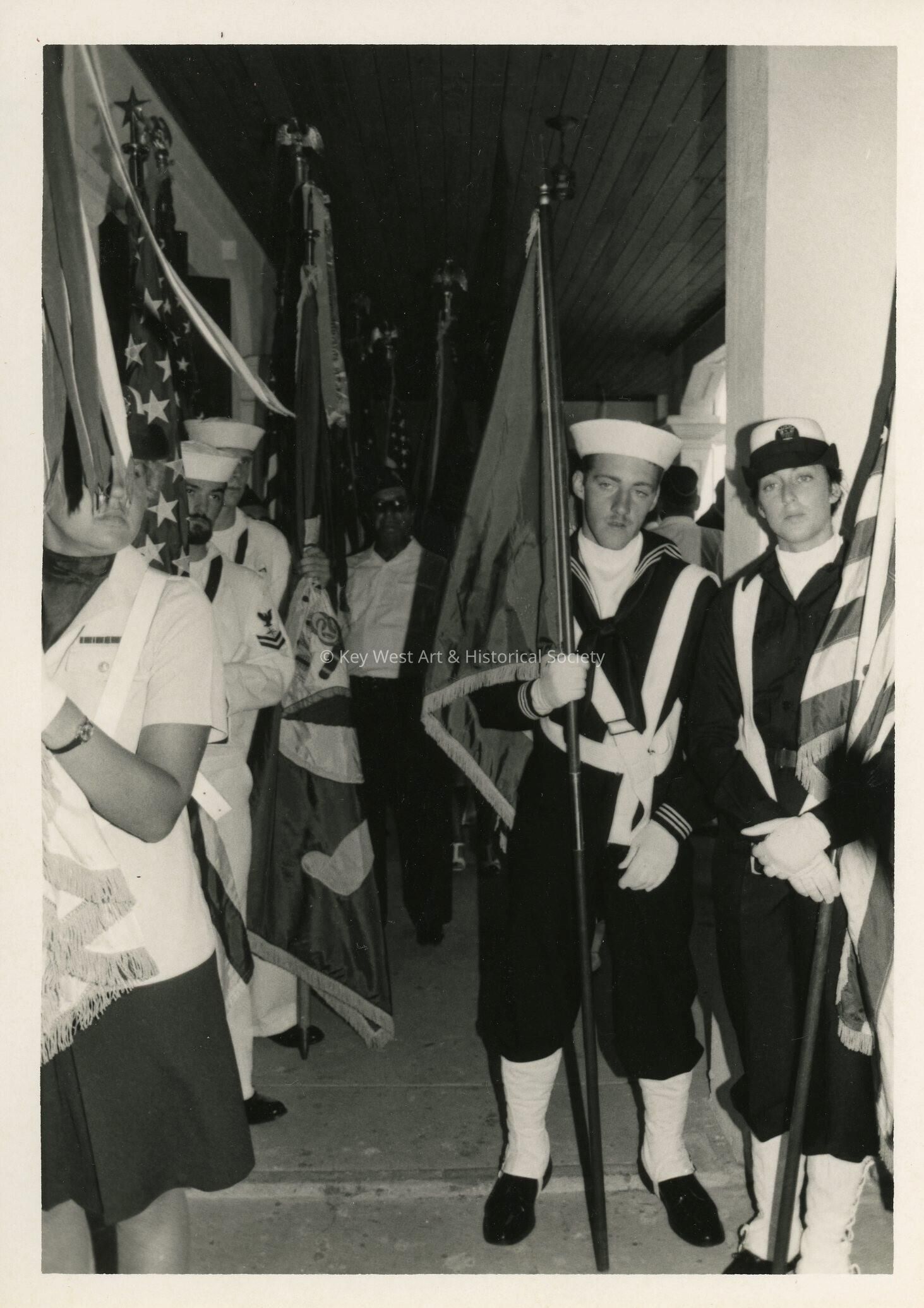 A group in uniform holding flags
