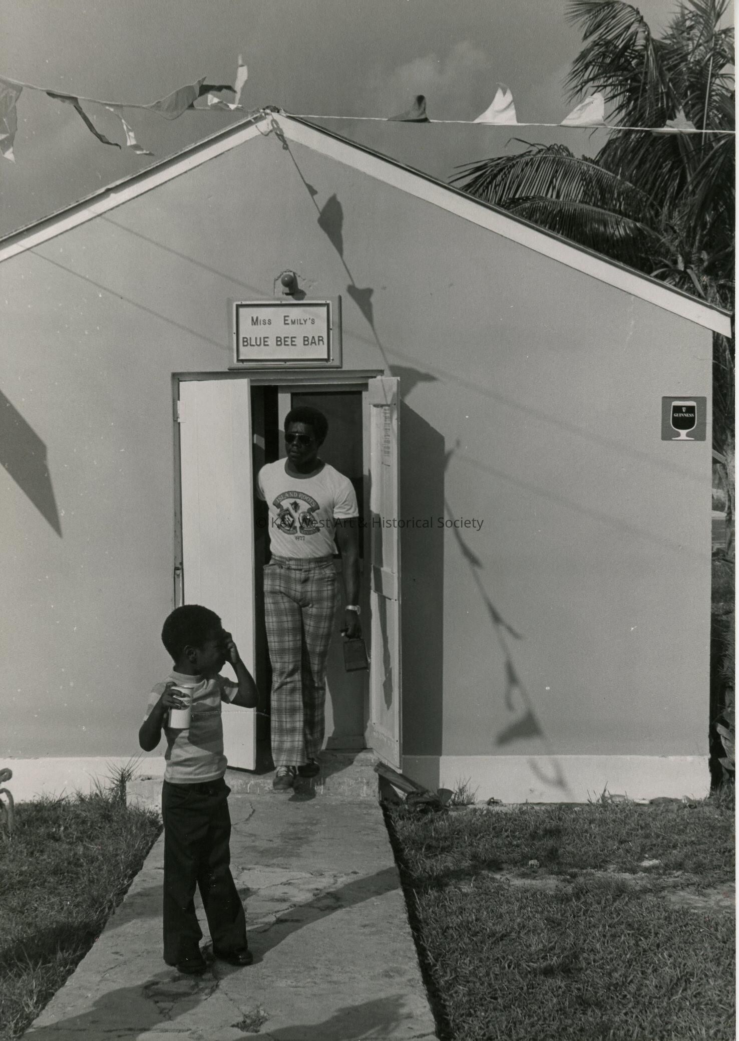 A man and child walking out of the Blue Bee Bar