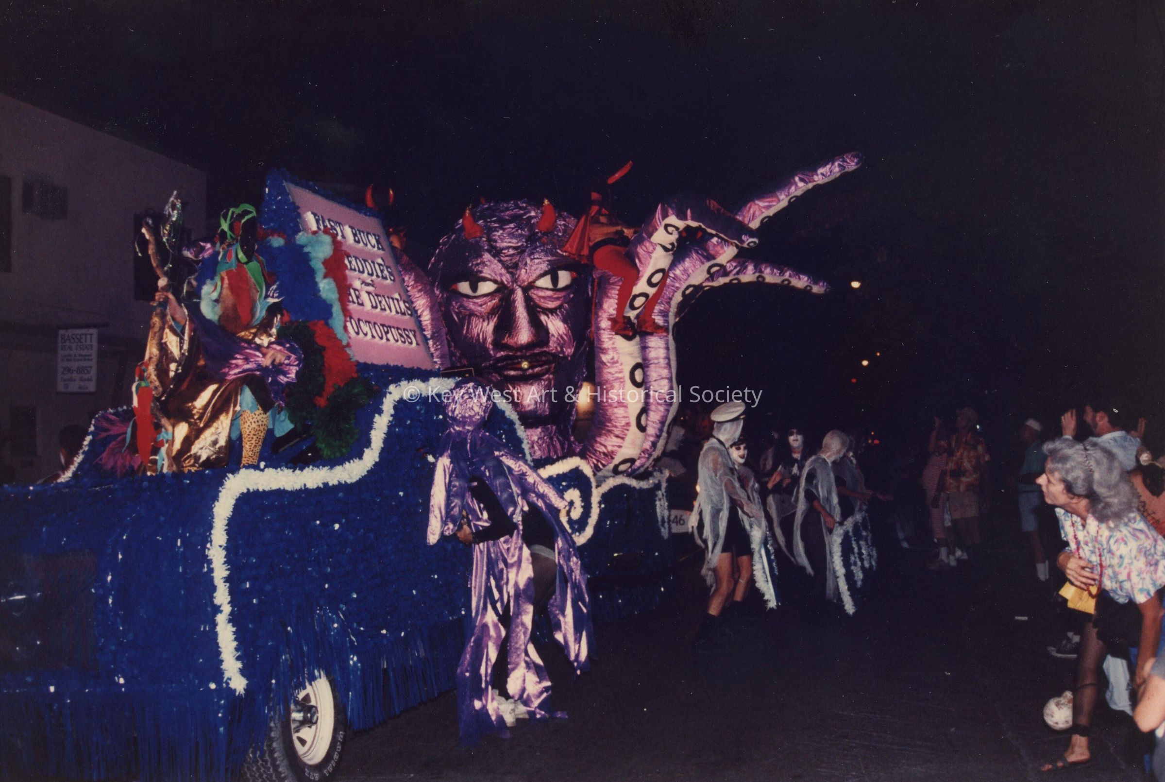 A float in the parade that reads Fast Buck Freddie's.