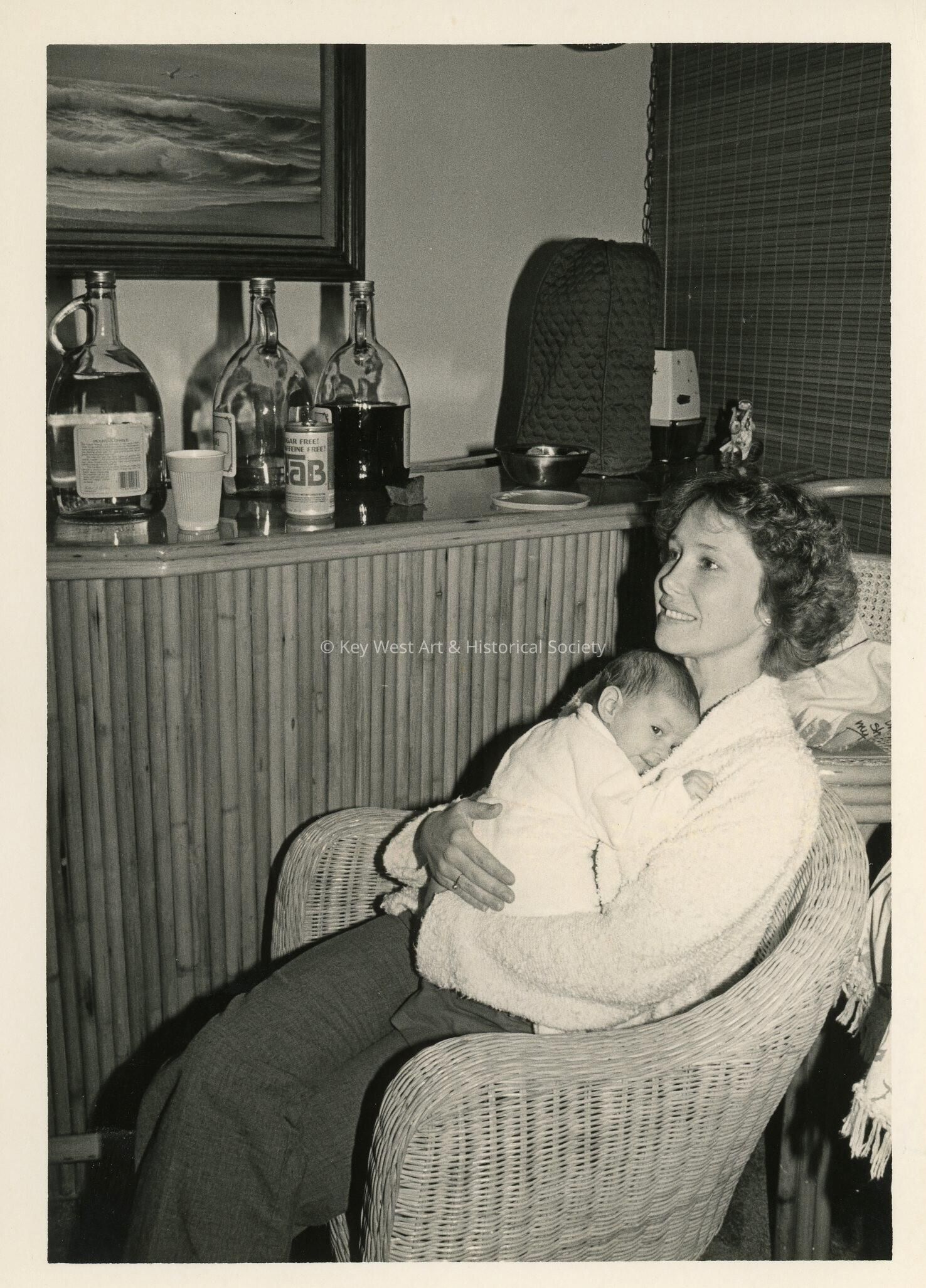 An unknown woman at a party holding a baby