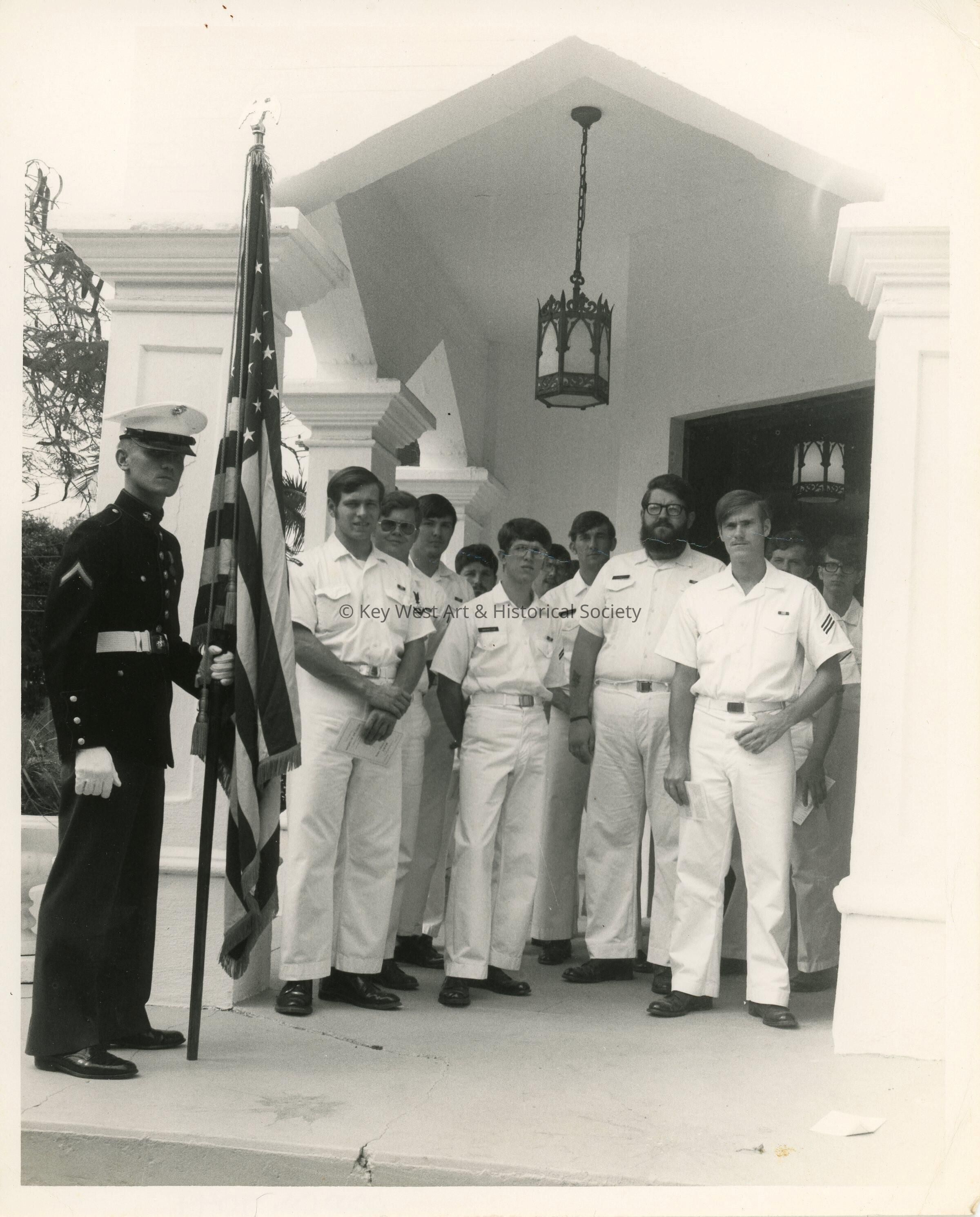 A group of unknown men in uniform standing outside of a building