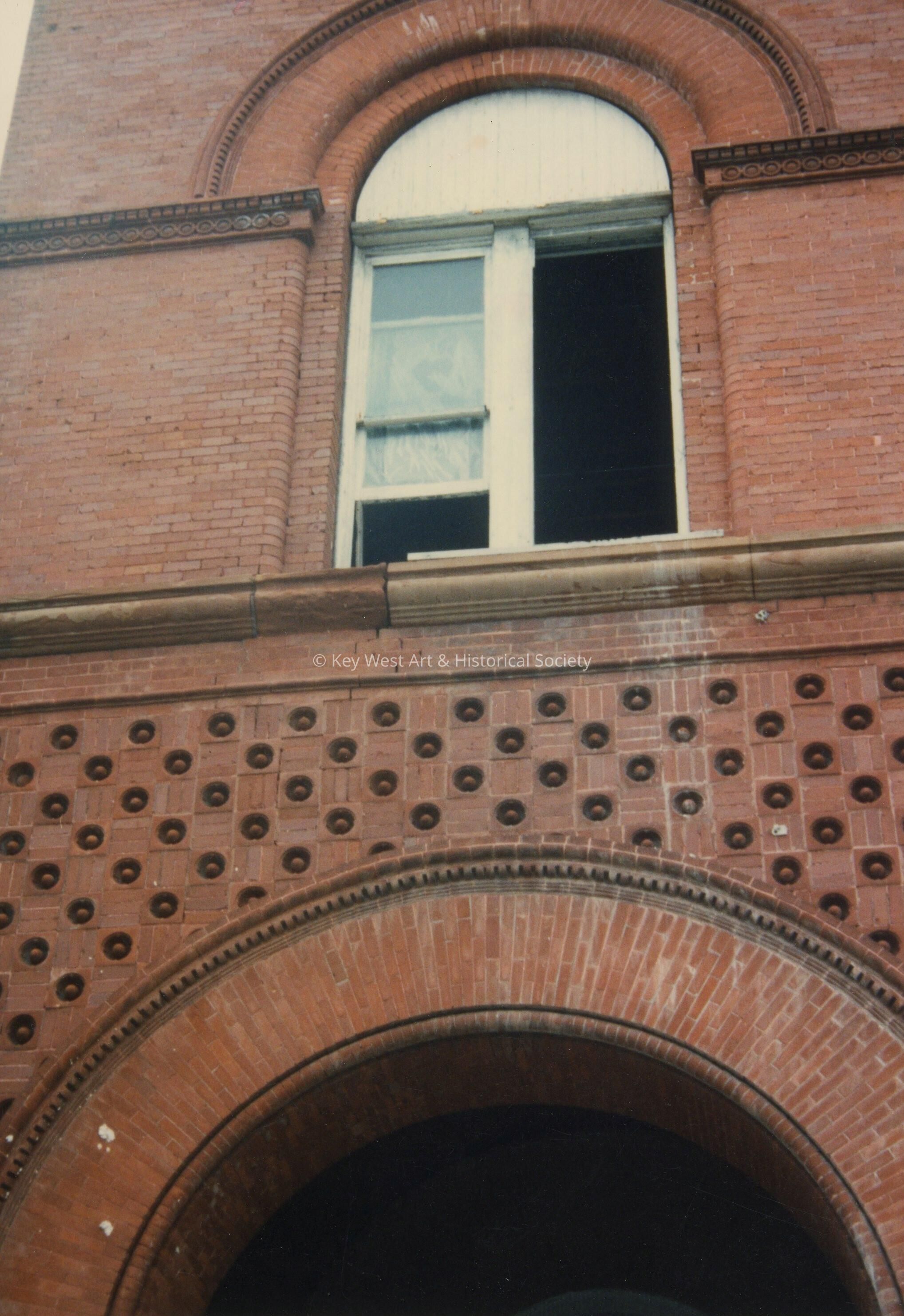 A brick arch and a second floor window.