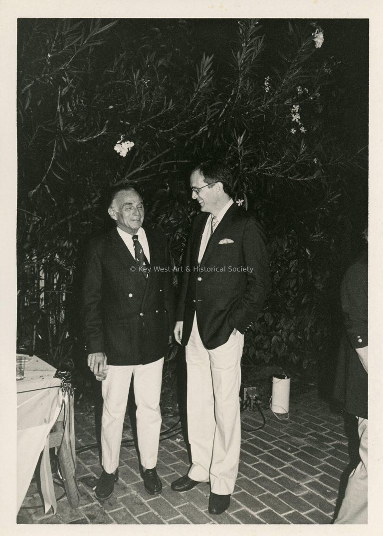 2 Unknown men standing outside at a party