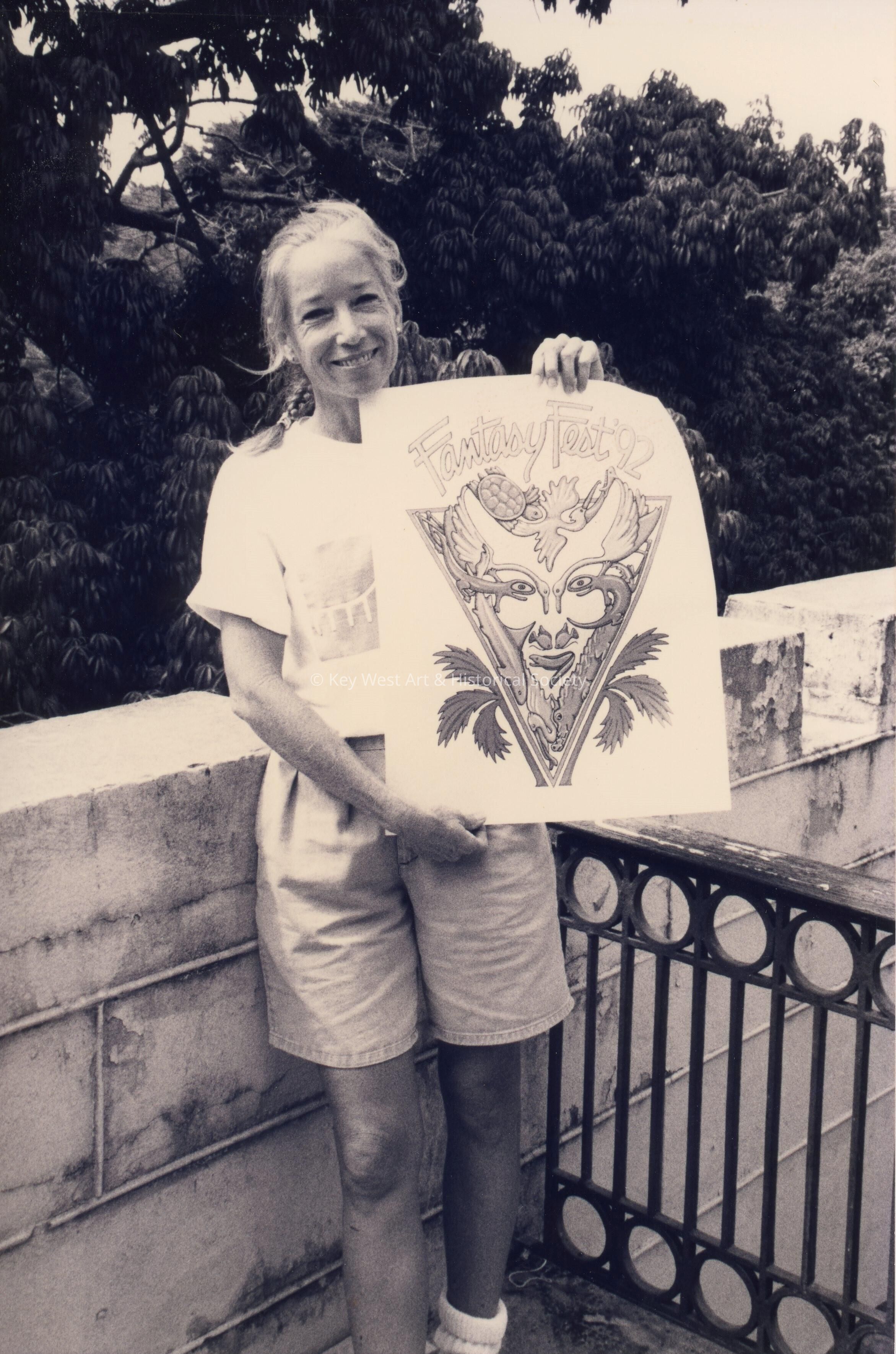 An unknown woman holding up a drawing that reads FF 92.