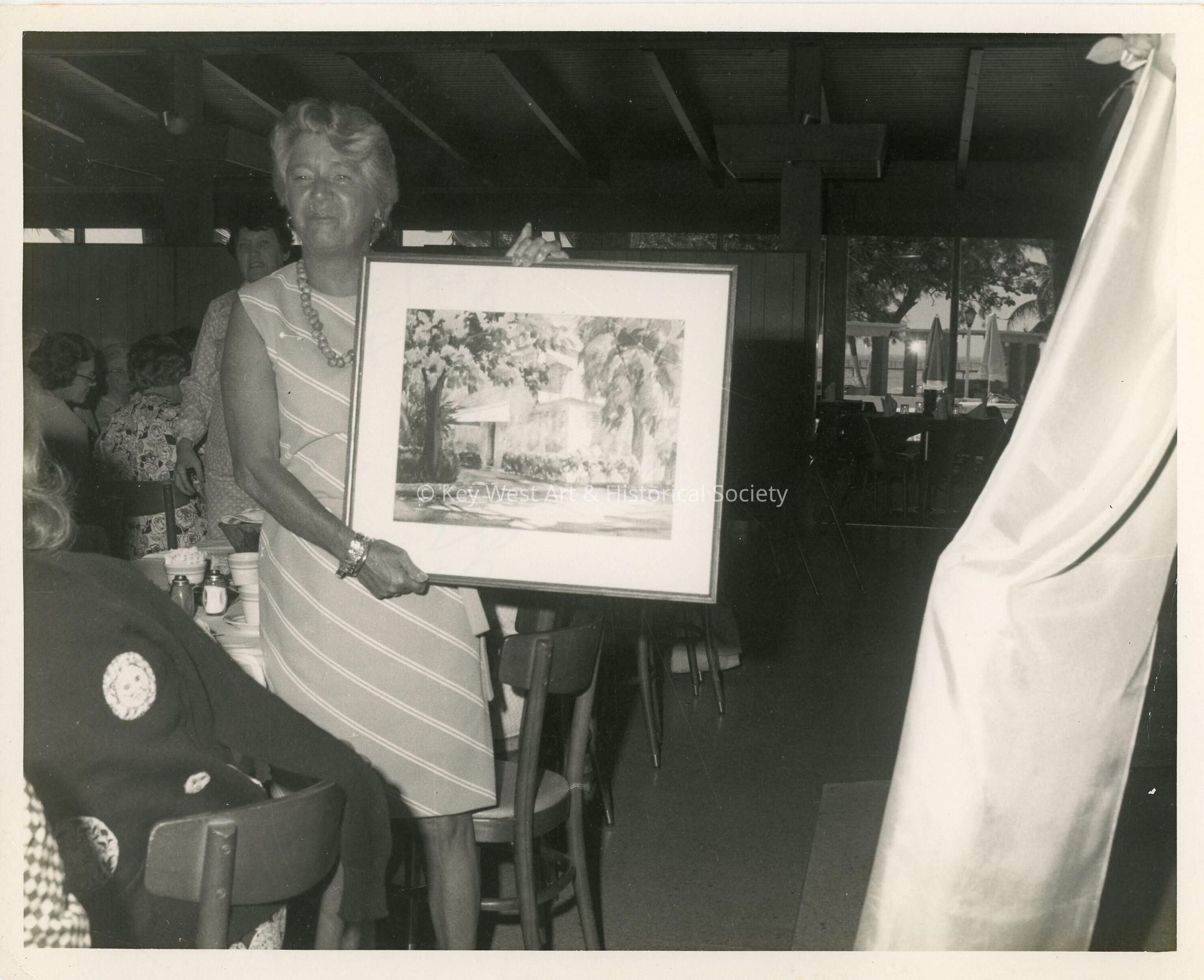 An unknown lady holding art work