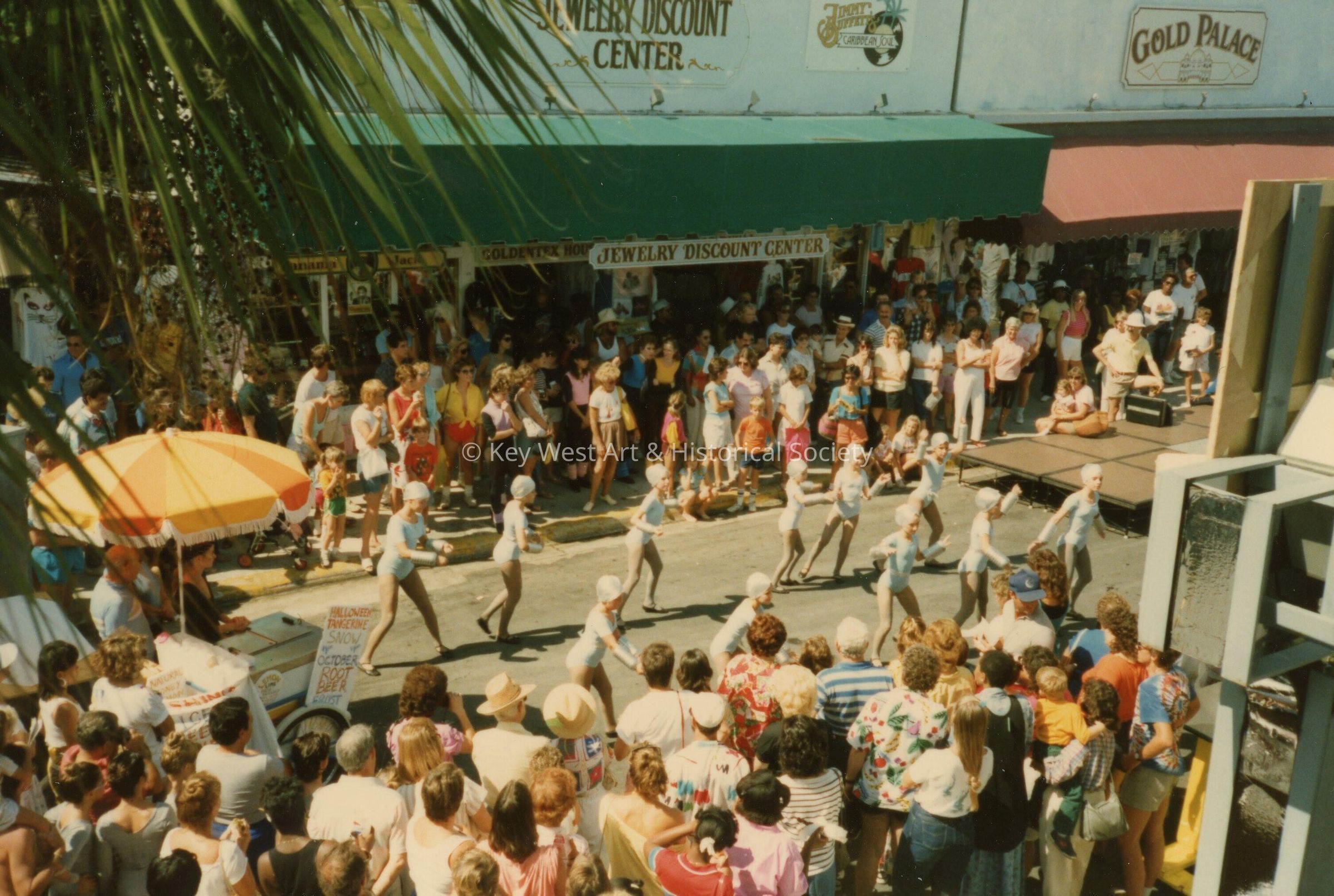 A group of unknown people performing on the street in front of a crowd.