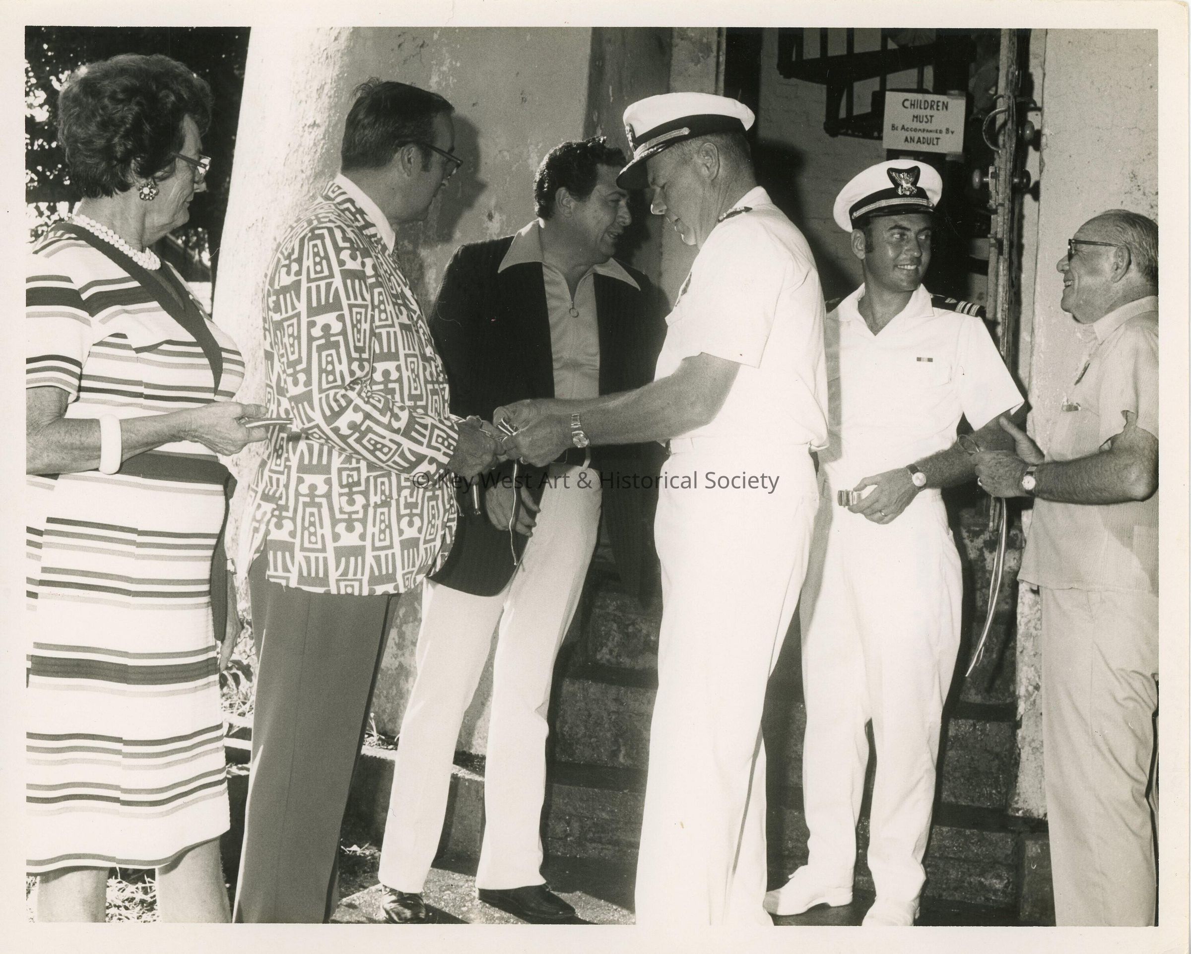 A few unknown men in uniform talking to a group of people