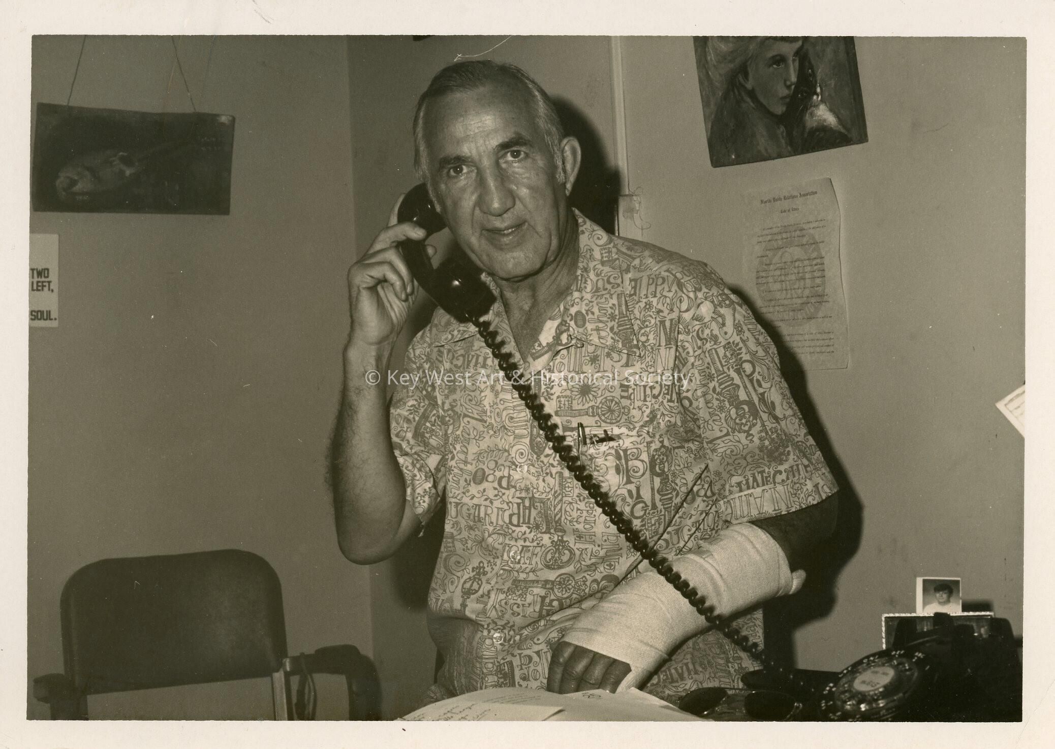 An unknown man using a telephone