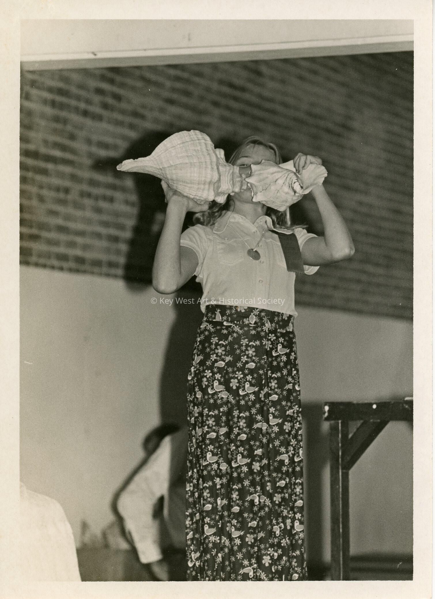 A child holding 2 shells