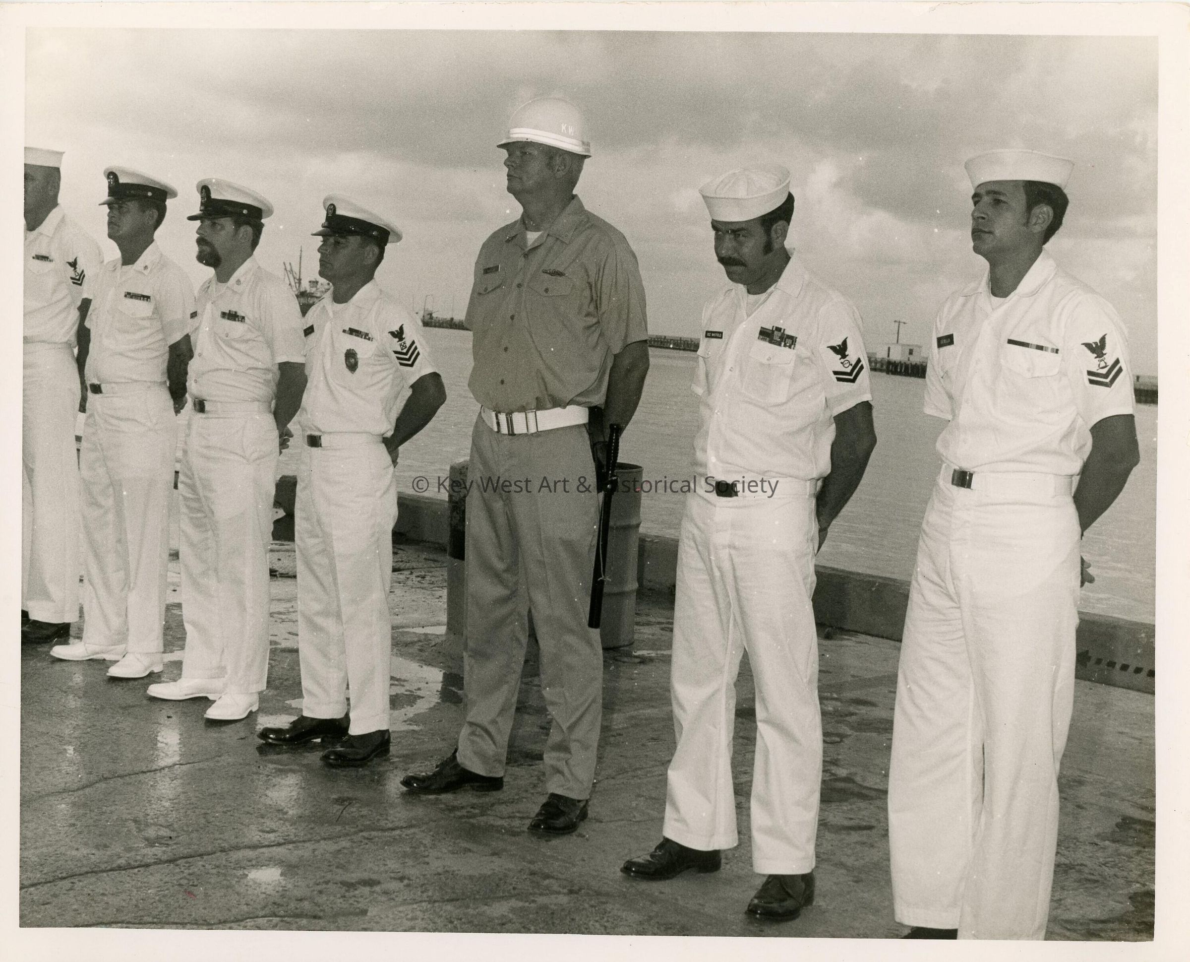 A group of men in uniform standing by the pier