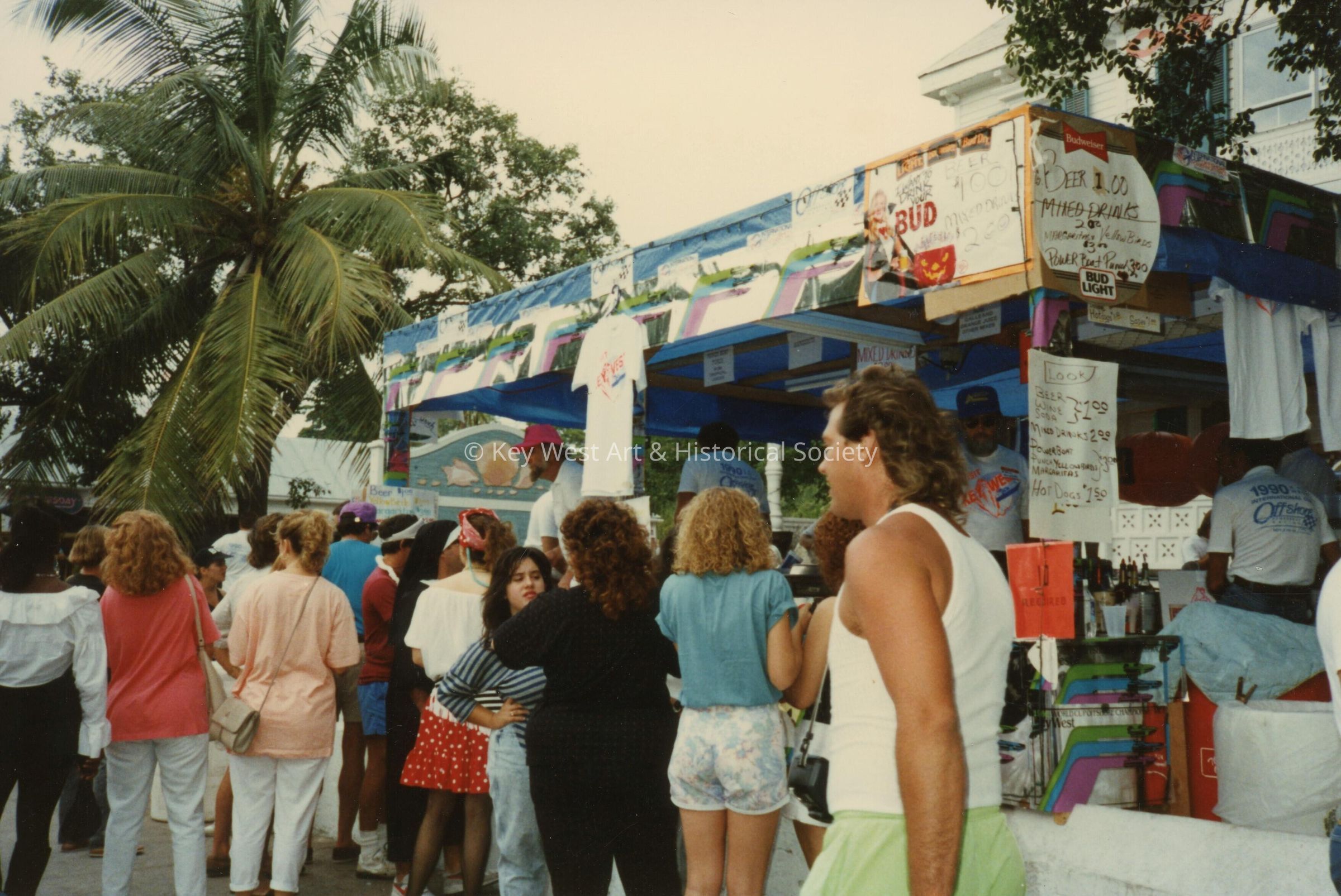 A group of unknown people standing near a booth.