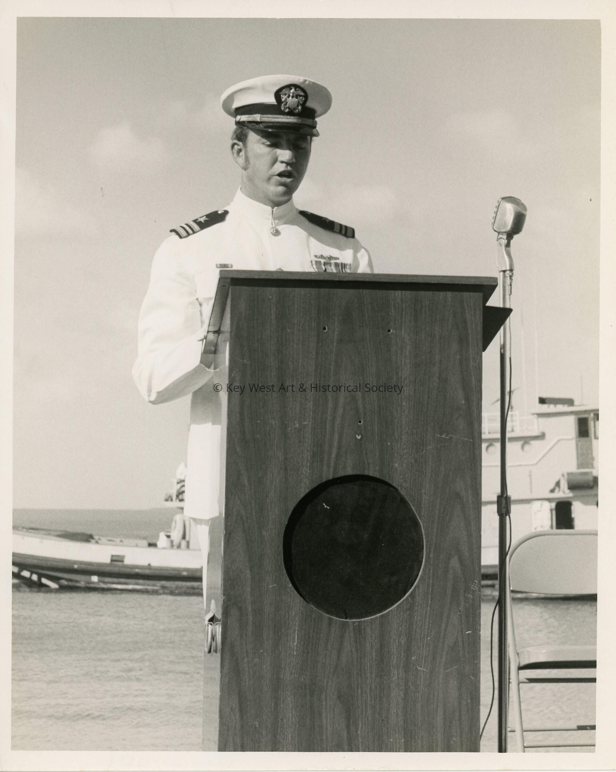 An unknown man in uniform standing at a podium