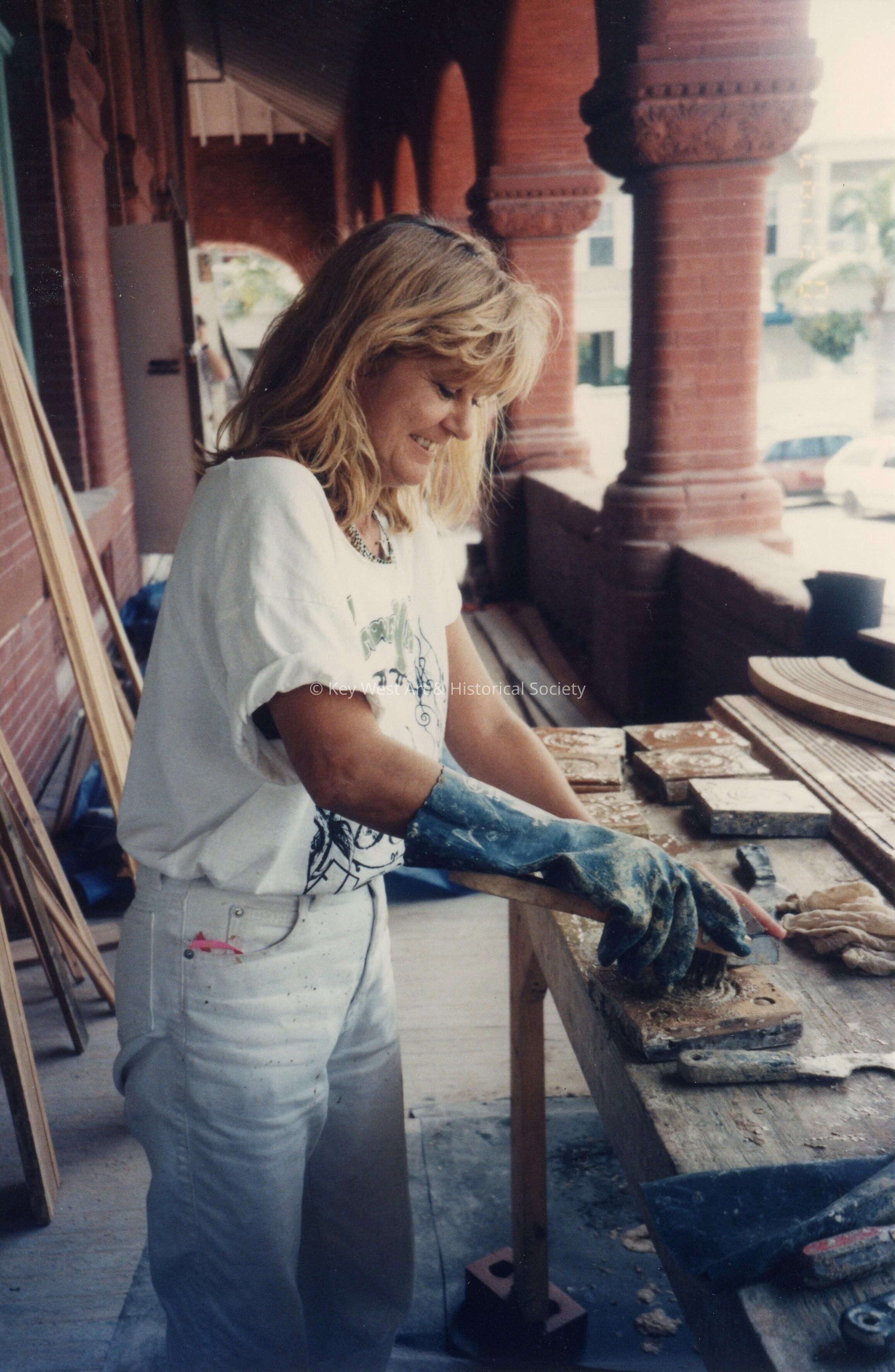 An unknown woman working on the terra cotta outside on the porch.