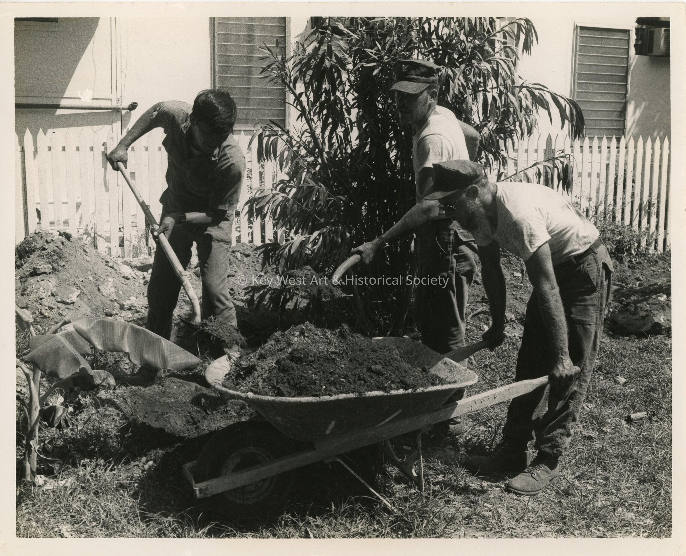3 Unknown men cleaning a yard