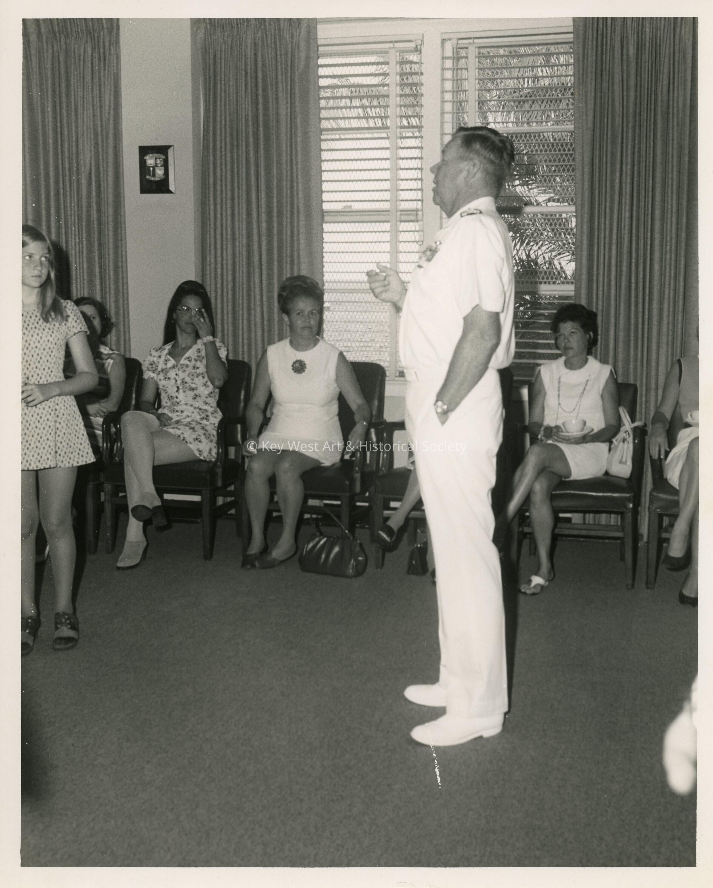 An unknown man talking to a group of people