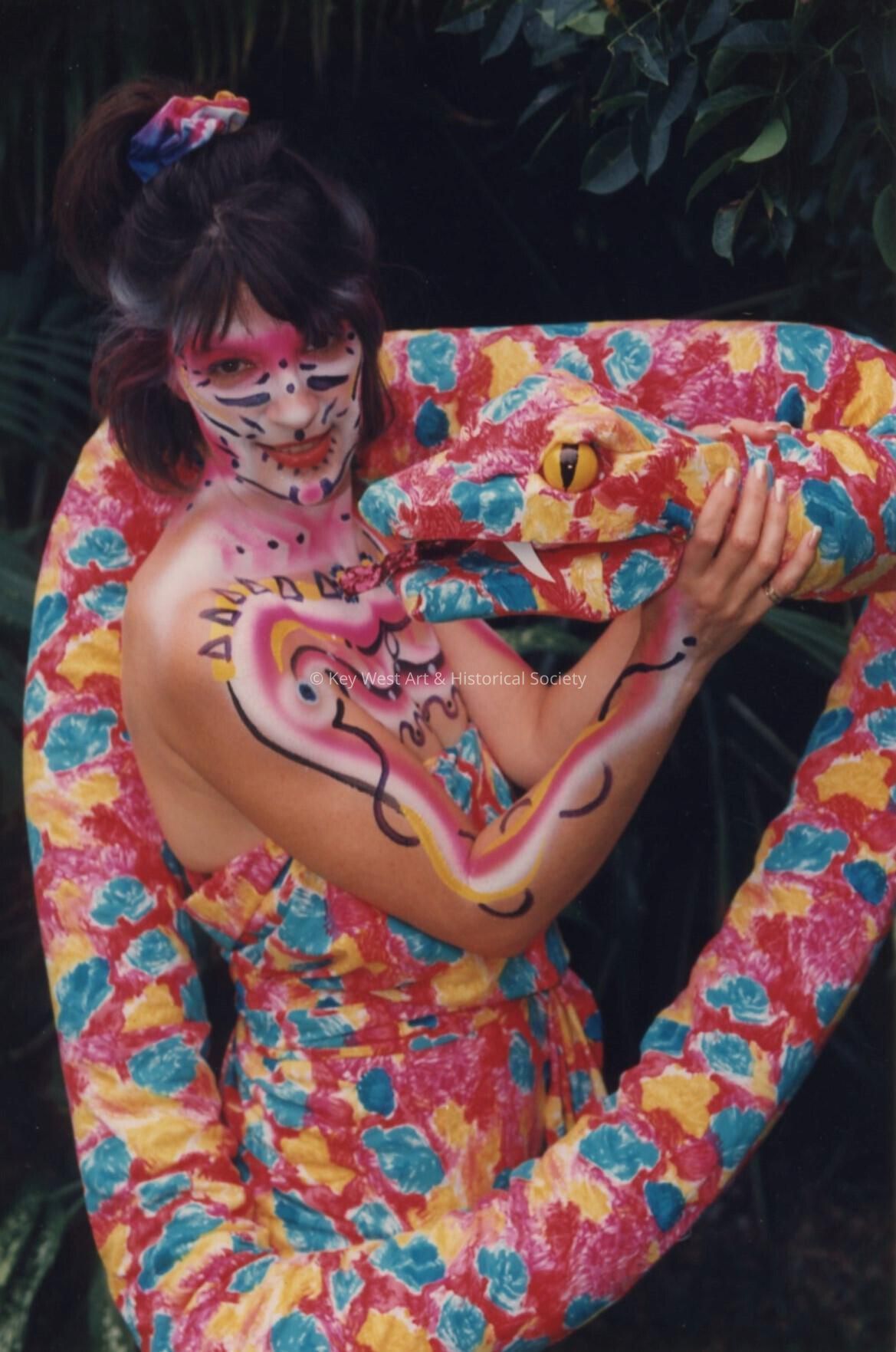 An unknown woman painted and dressed like a snake.