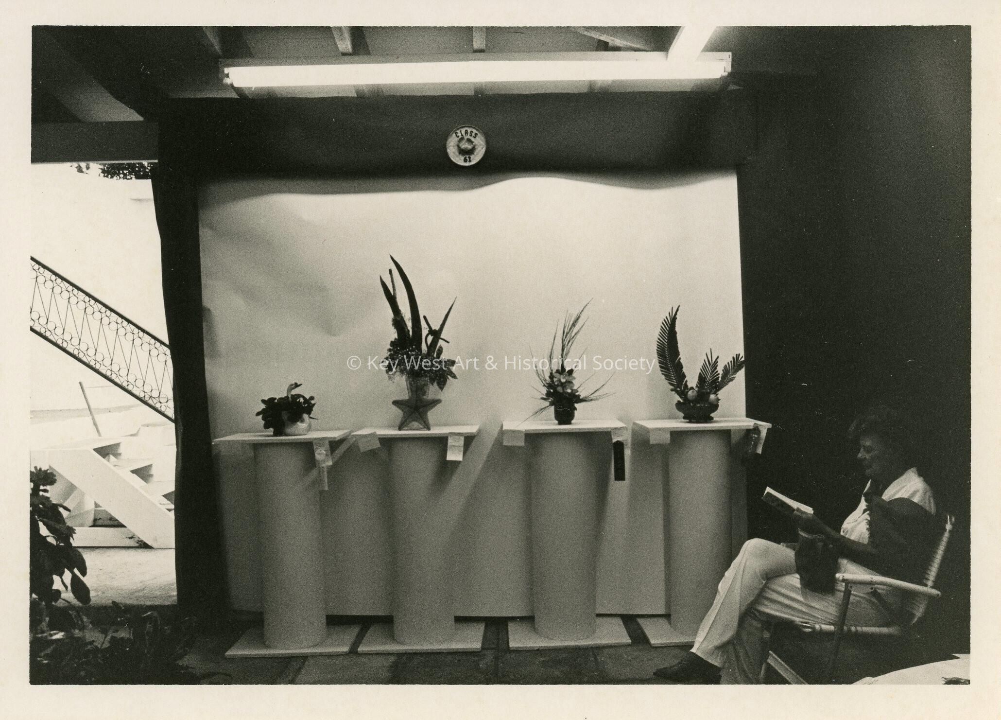 An unknown woman sitting next to plants
