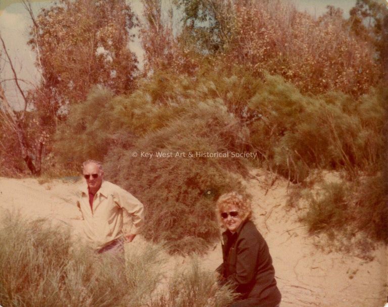 2 Unknown people outside with trees around them